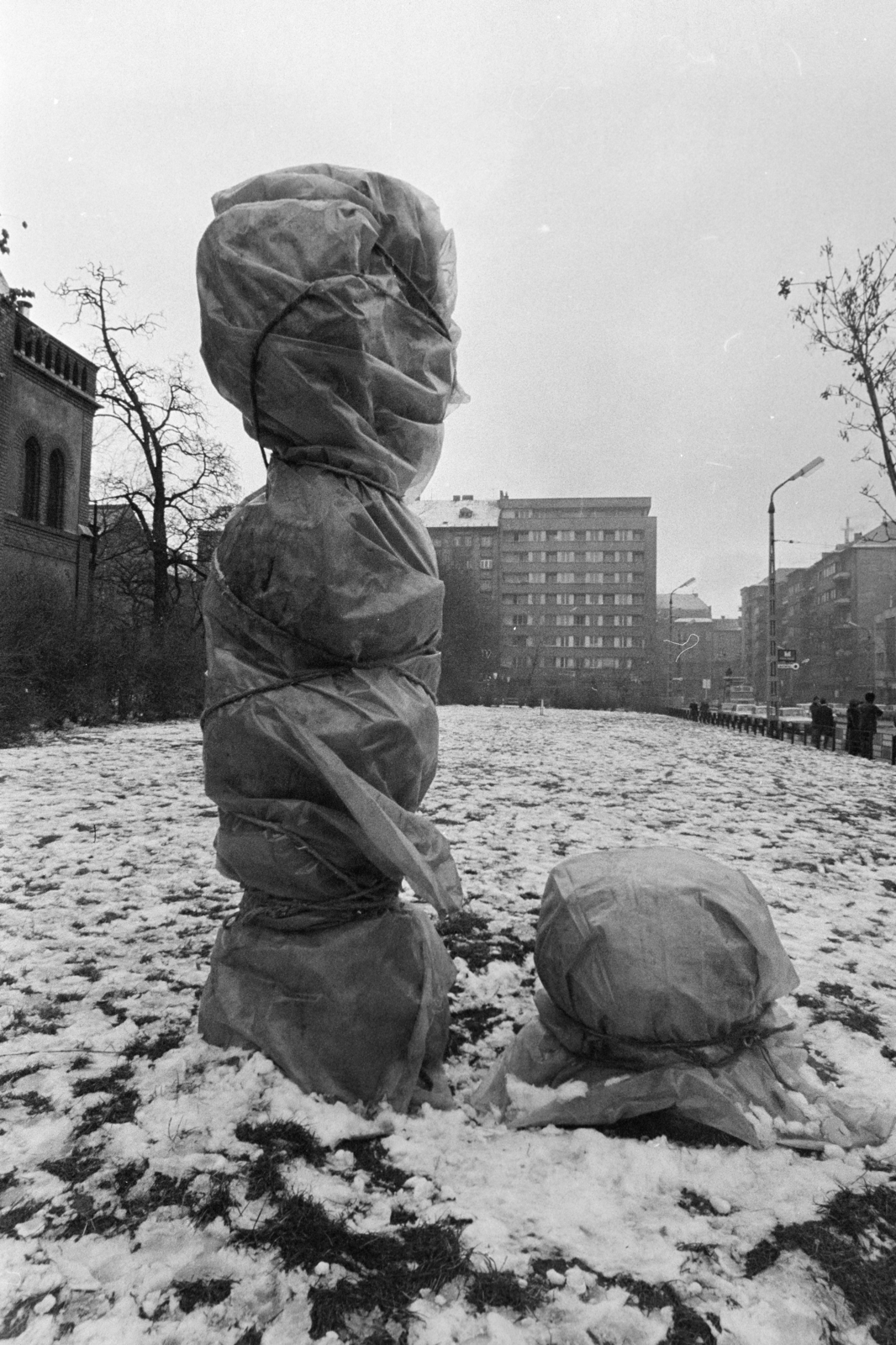 Magyarország, Budapest VII., Reformációi park (ekkor névtelen) a Városligeti (Gorkij) fasor - Bajza utca saroknál. Előtérben Végvári Gyula keramikus 1973-ban felállított térplasztikája télire becsomagolva. Háttérben jobbra a Garzonház.
, 1974, Kereki Sándor, Budapest, szobor, Fortepan #205912