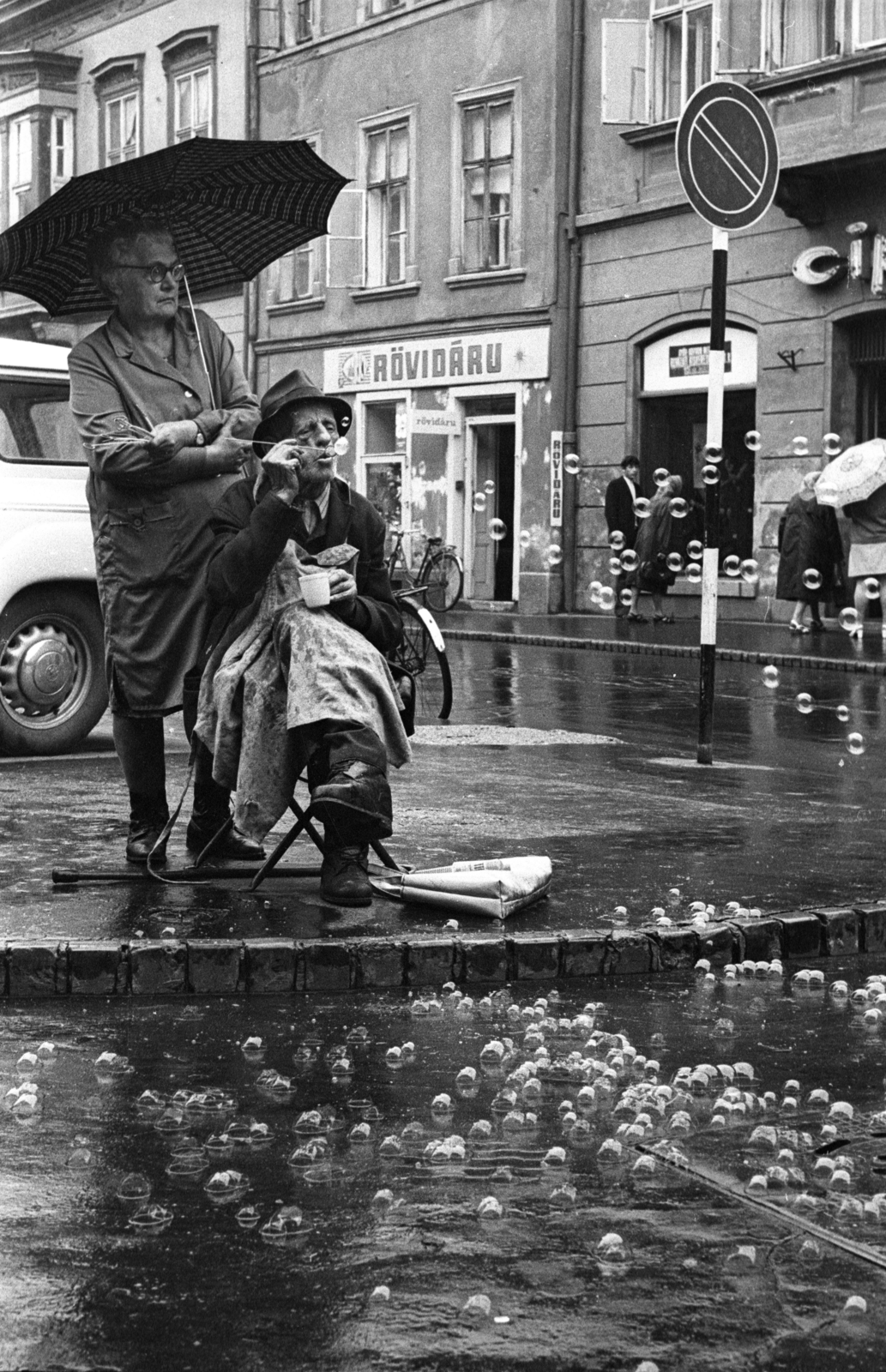 Hungary, Győr, szappanbuborék-fújó karikát árusító házaspár a Dr. Kovács Pál utca és a Király (Alkotmány) utca találkozásánál., 1970, Kereki Sándor, hat, umbrella, soap bubble, blowing a bubble, Best of, man and woman, haberdashery, bicycle, Fortepan #206184