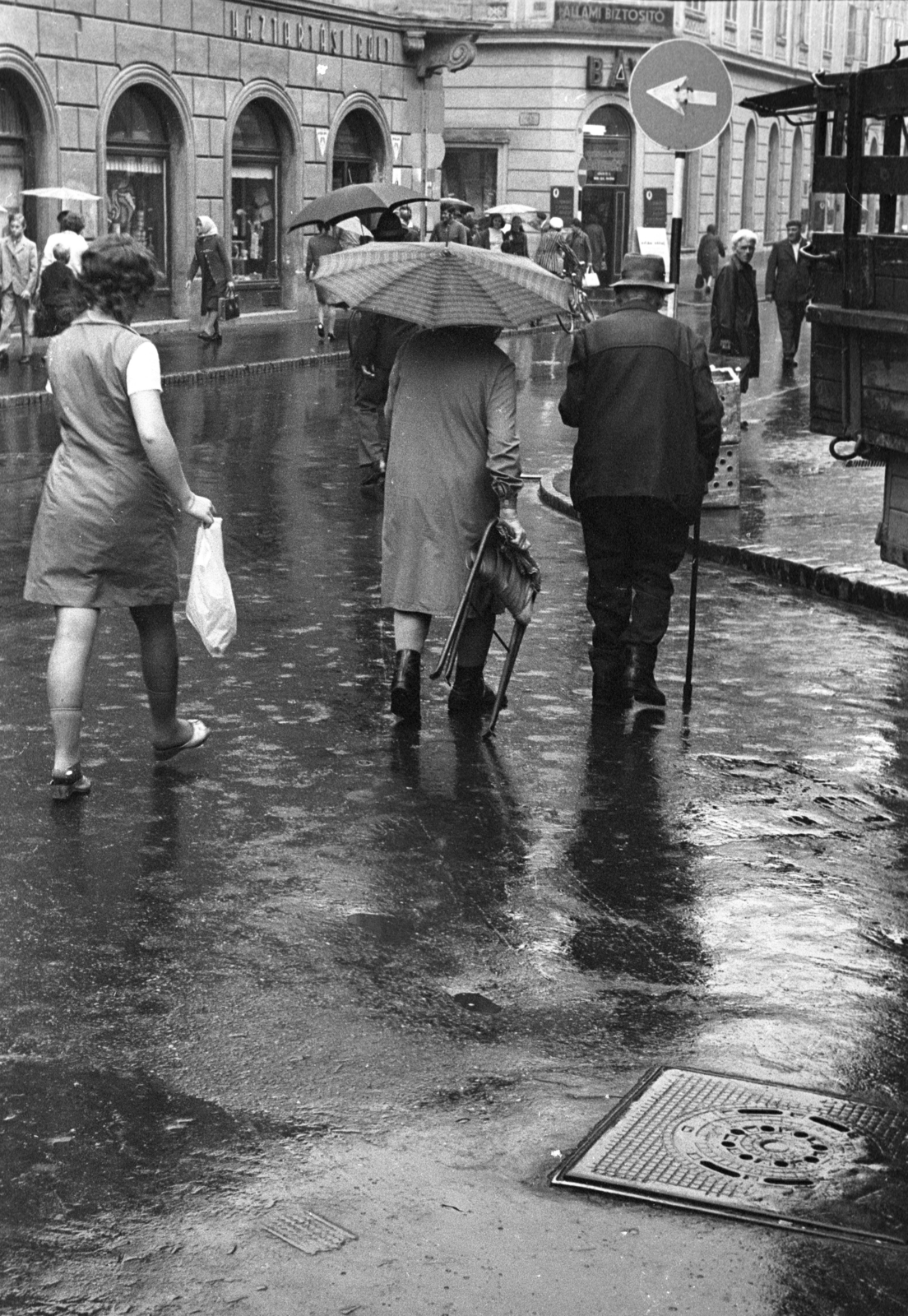Hungary, Győr, Király (Alkotmány) utca, balra a Baross Gábor út torkolata. Szappanbuborék-fújó karikát árusító házaspár tart hazafelé., 1970, Kereki Sándor, umbrella, pedestrian, back, Fortepan #206186