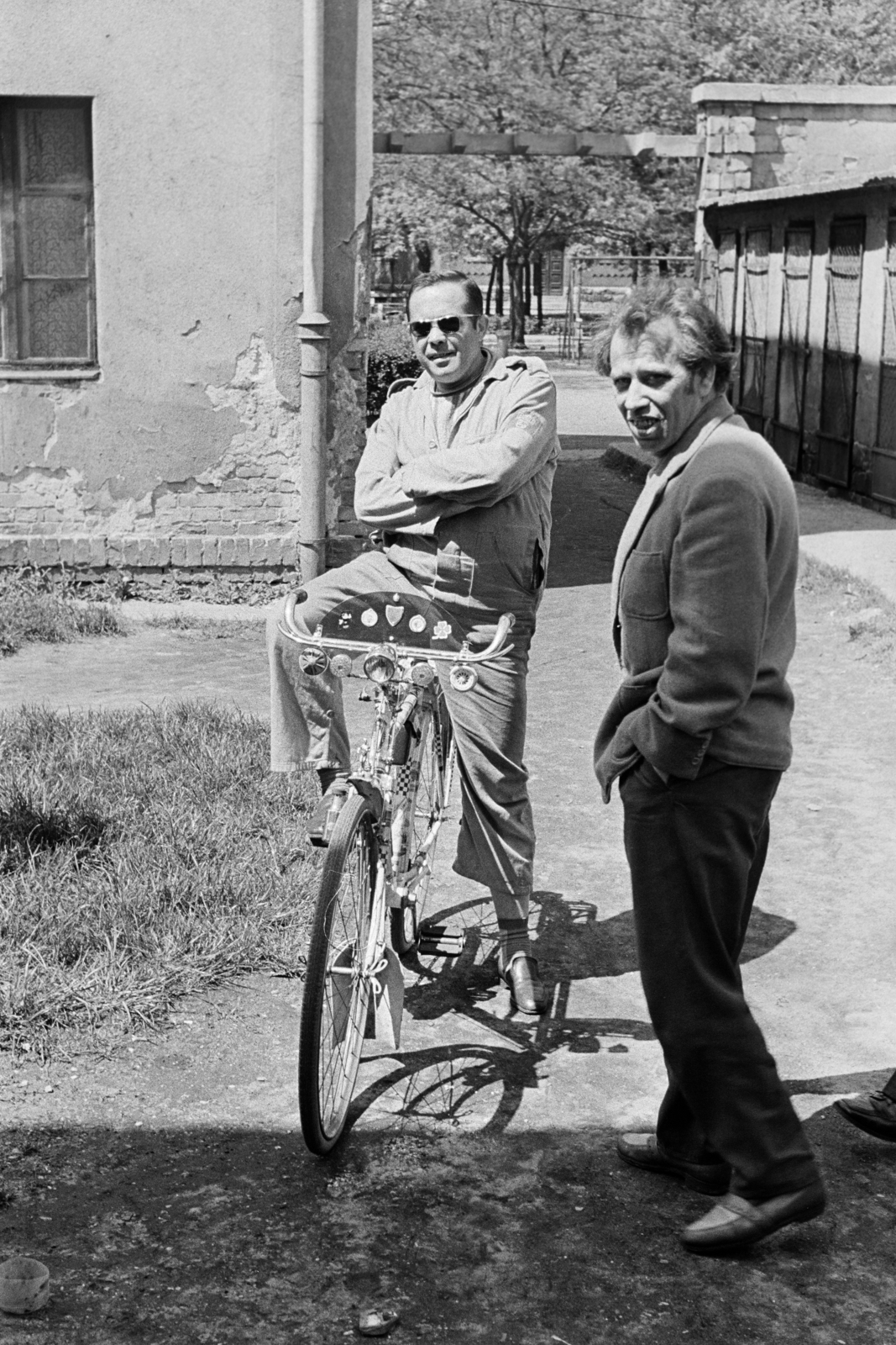 Hungary, Budapest XIII., "Tripolisz" lakótelep a Tomori utca felé nézve, a háttérben a Szent Mihály-templom oldalbejárata., 1973, Kereki Sándor, bicycle, Budapest, shades, arms crossed over the chest, looking back, hands in pockets, men, Fortepan #206470