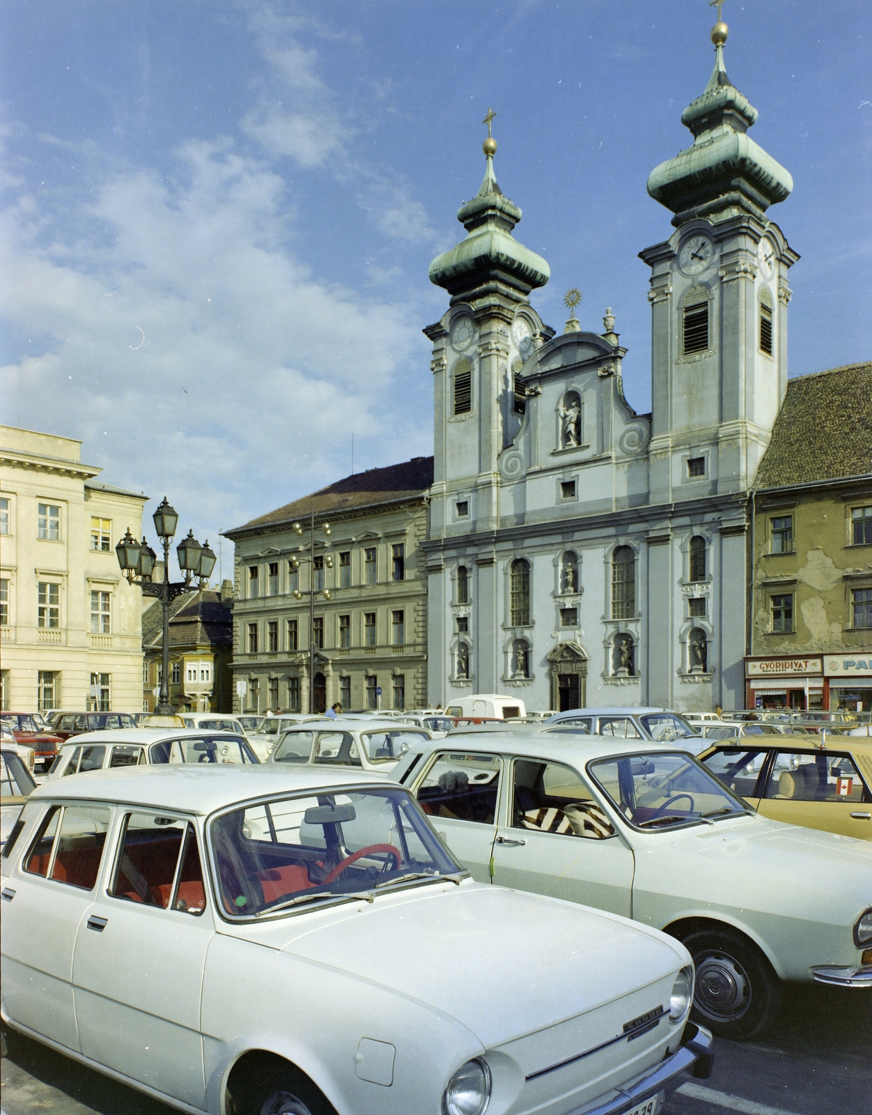 Hungary, Győr, Széchenyi tér, Loyolai Szent Ignác bencés templom. Mellette balra a Czuczor Gergely Bencés Gimnázium, 1977, FŐFOTÓ, colorful, street view, church, automobile, Fortepan #207165