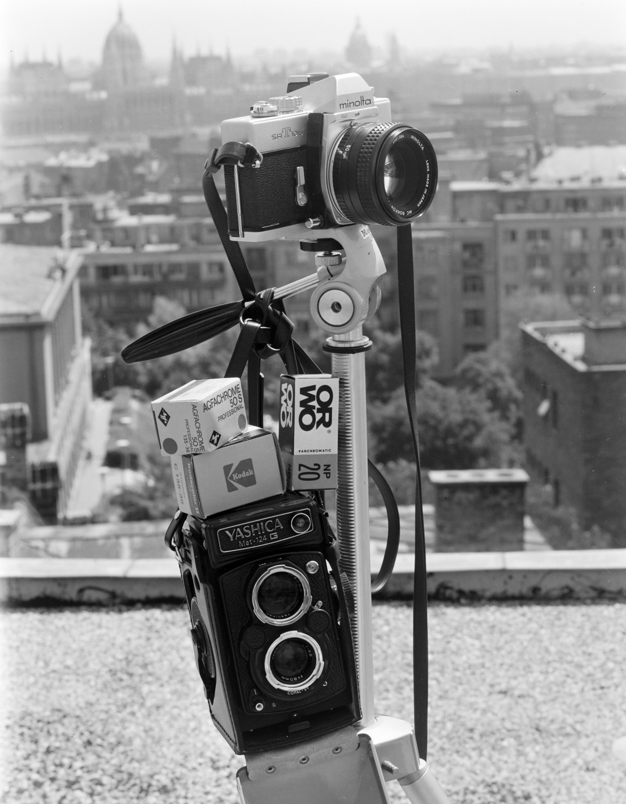 Hungary, Budapest II., fényképezőgépek és negatív filmek reklámfotója. A felvétel a Rózsahegy utca 4-es számú ház tetején készült, balra a Kerületi Tanács (később Polgármesteri Hivatal) épülete, távolban a Parlament., 1977, FŐFOTÓ, camera, Budapest, tripod, advertising photography, Minolta SRT 101b, film roll, Fortepan #207246