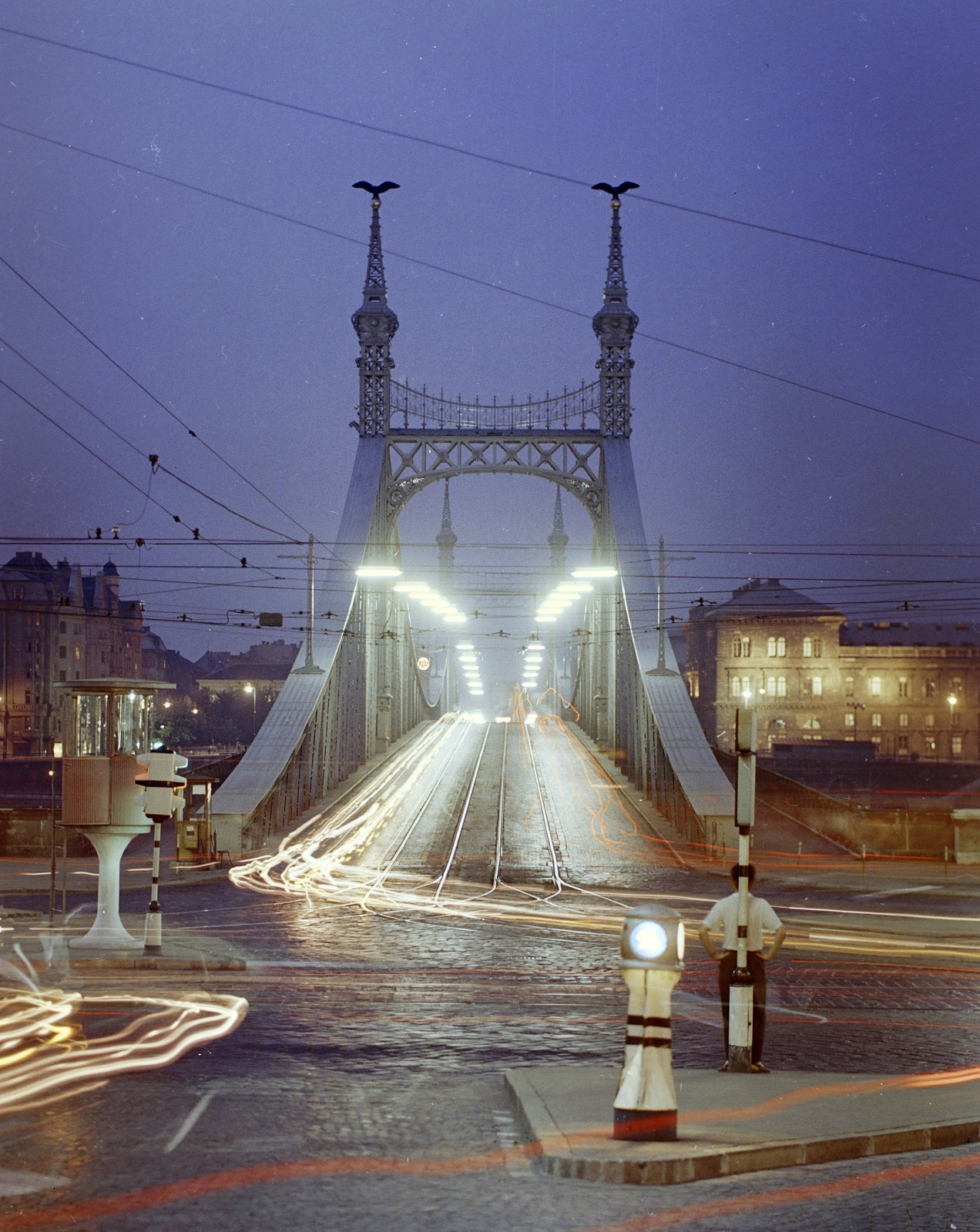 Magyarország, Budapest XI.,Budapest V.,Budapest IX., Szent Gellért tér, Szabadság híd budai hídfő. A túlparton a Fővám (Dimitrov) tér és jobbra a Marx Károly Közgazdaságtudományi Egyetem (később Corvinus Egyetem) épülete., 1970, FŐFOTÓ, színes, Budapest, bemozdulás, éjszaka, csibilámpa, Fortepan #207555