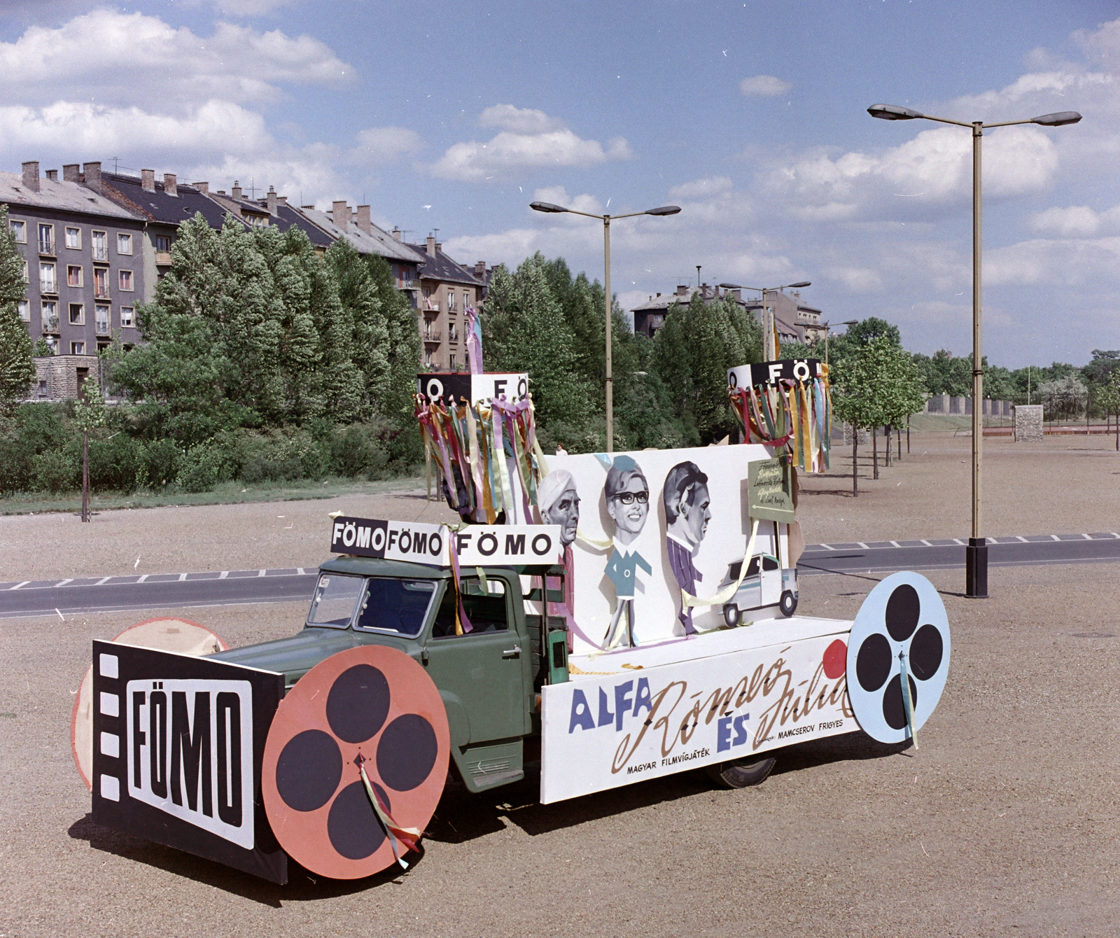 Magyarország, Budapest XIV., a Népstadion melletti terület, háttérben a Stefánia (Népstadion) út házsora. A Fővárosi Moziüzemi Vállalat (FŐMO) által forgalmazott film plakátja a Színészek-Újságírók Rangadó (SZÚR) alkalmával felvonuló teherautón., 1969, FŐFOTÓ, Budapest, pódiumautó, filmplakát, Fortepan #208456
