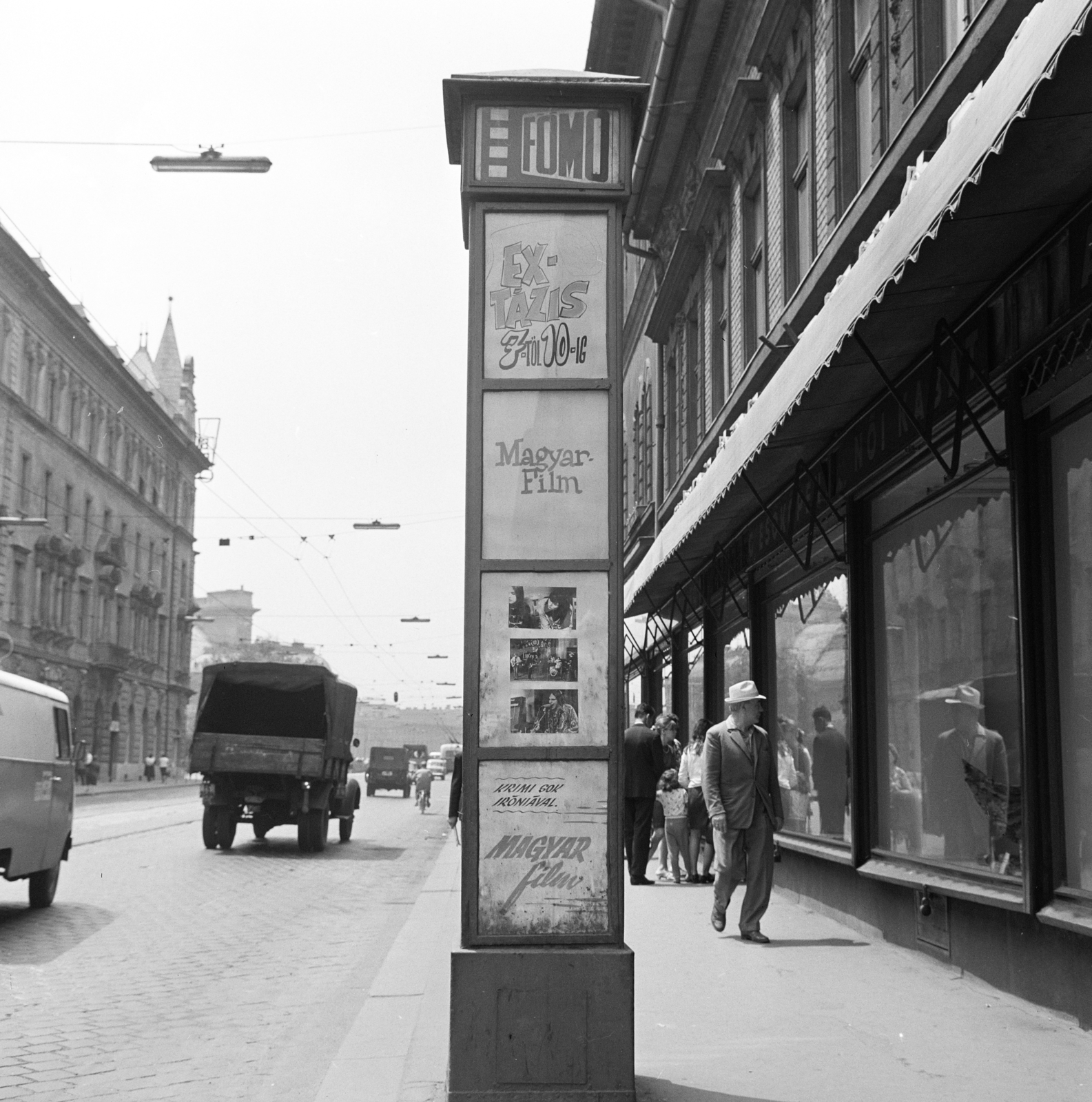 Magyarország, Budapest VII.,Budapest VIII., a Thököly út, a Fővárosi Moziüzemi Vállalat (FŐMO) által forgalmazott filmek hirdetőoszlopa. Távolban a Keleti pályaudvar sziluetje a Baross téren., 1969, FŐFOTÓ, Budapest, Fortepan #208668