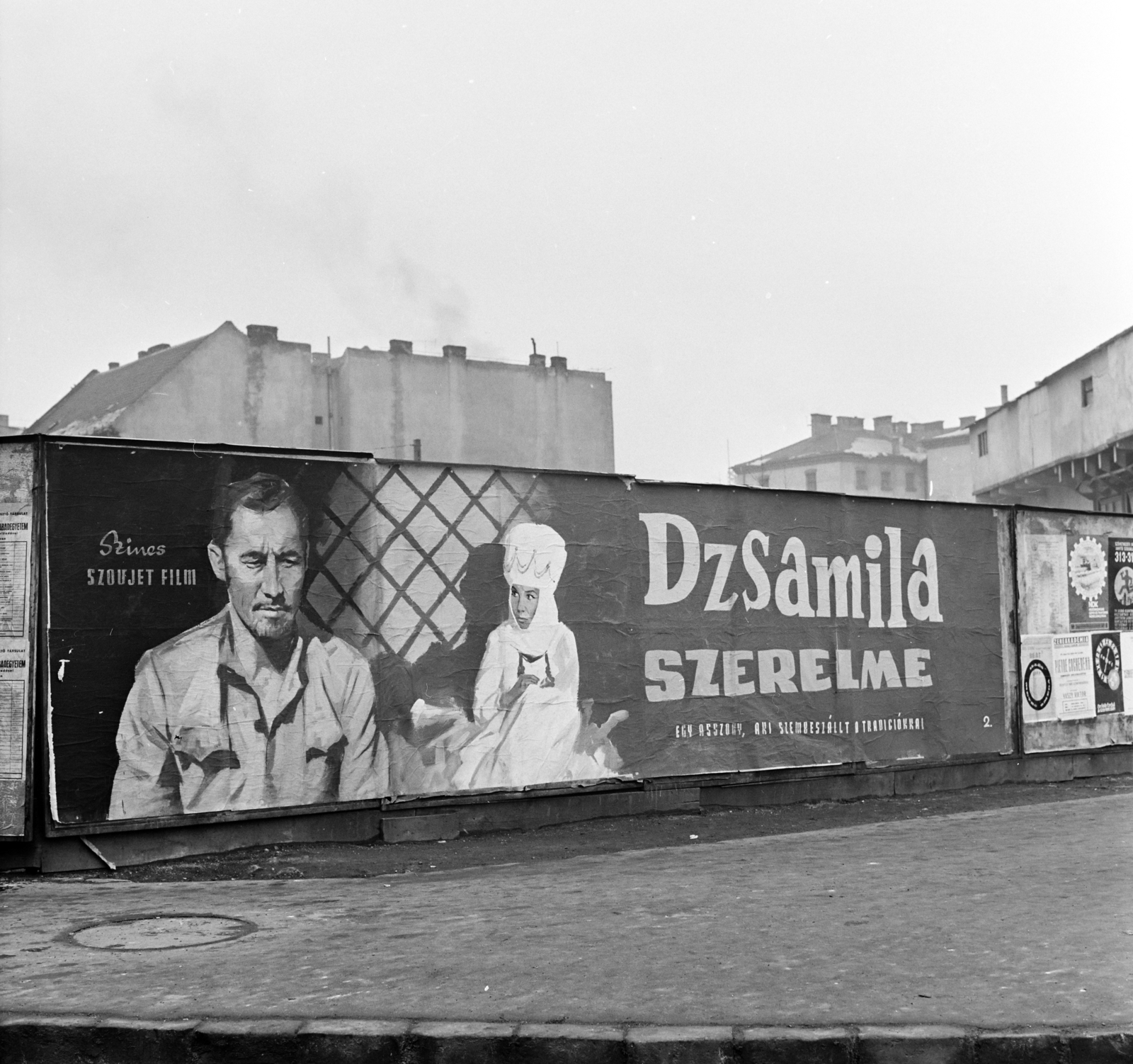 Hungary, Budapest II., Margit körút (Mártírok útja), előtérben a Retek utca és a Lövőház utca közötti metróépítési terület kerítése. A Fővárosi Moziüzemi Vállalat (FŐMO) által forgalmazott film plakátja. Háttérben középen a Margit körúti egykori fogház épülete, jobbra a Lövőház utca sarkán a metróépítés felvonótornya., 1970, FŐFOTÓ, Budapest, movie poster, Fortepan #208875