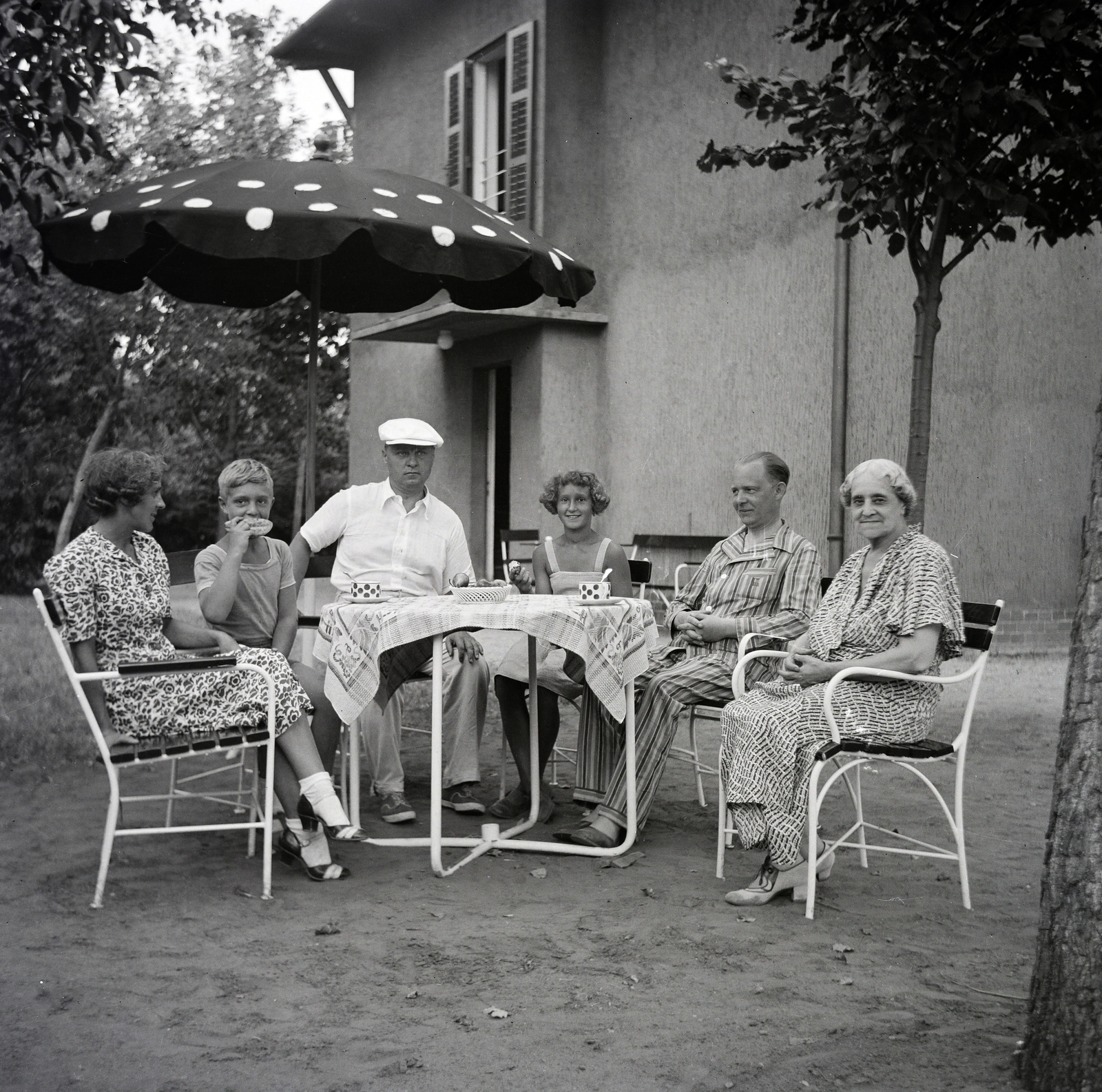 Hungary,Lake Balaton, Siófok, Szabadifürdő (ekkor Balatonszabadi település része)., 1938, Belházy Miklós, odd one out, tableau, photo aspect ratio: square, nightgown, socks and sandal, sunshades, garden furniture, Fortepan #210169