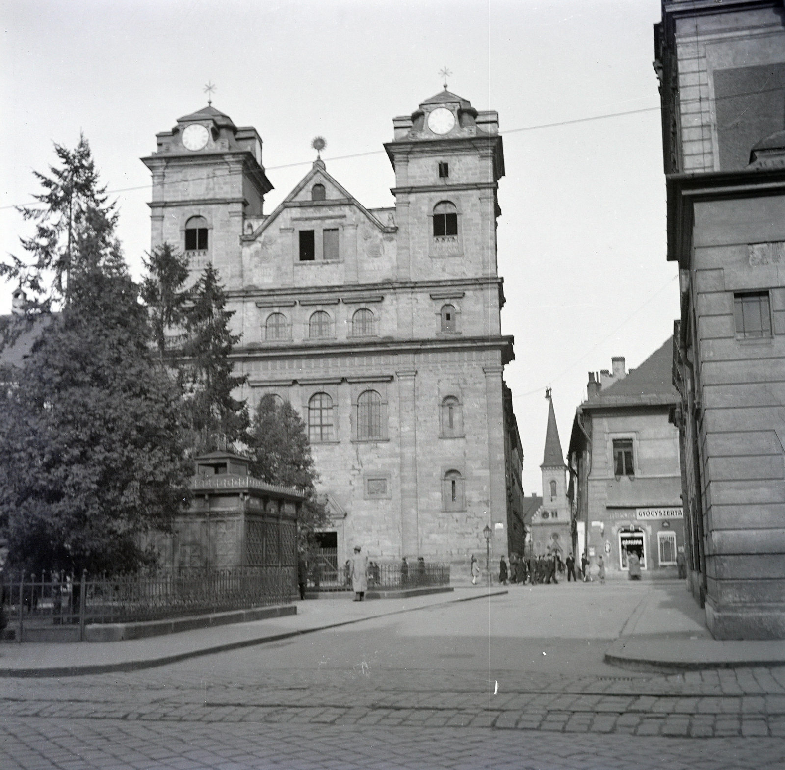 Szlovákia, Kassa, Fő tér (Hlavné namestie), szemben a Szentháromság-templom, mellette jobbra az Univerzitna ulica és folytatásában az ulica Pri Miklušovej väznici (ekkor Kálvin tér / Kalvínovo námestie) és a református templom. A kép jobb szélén az Állami Színház épületének sarka., 1938, Belházy Miklós, Fortepan #210178