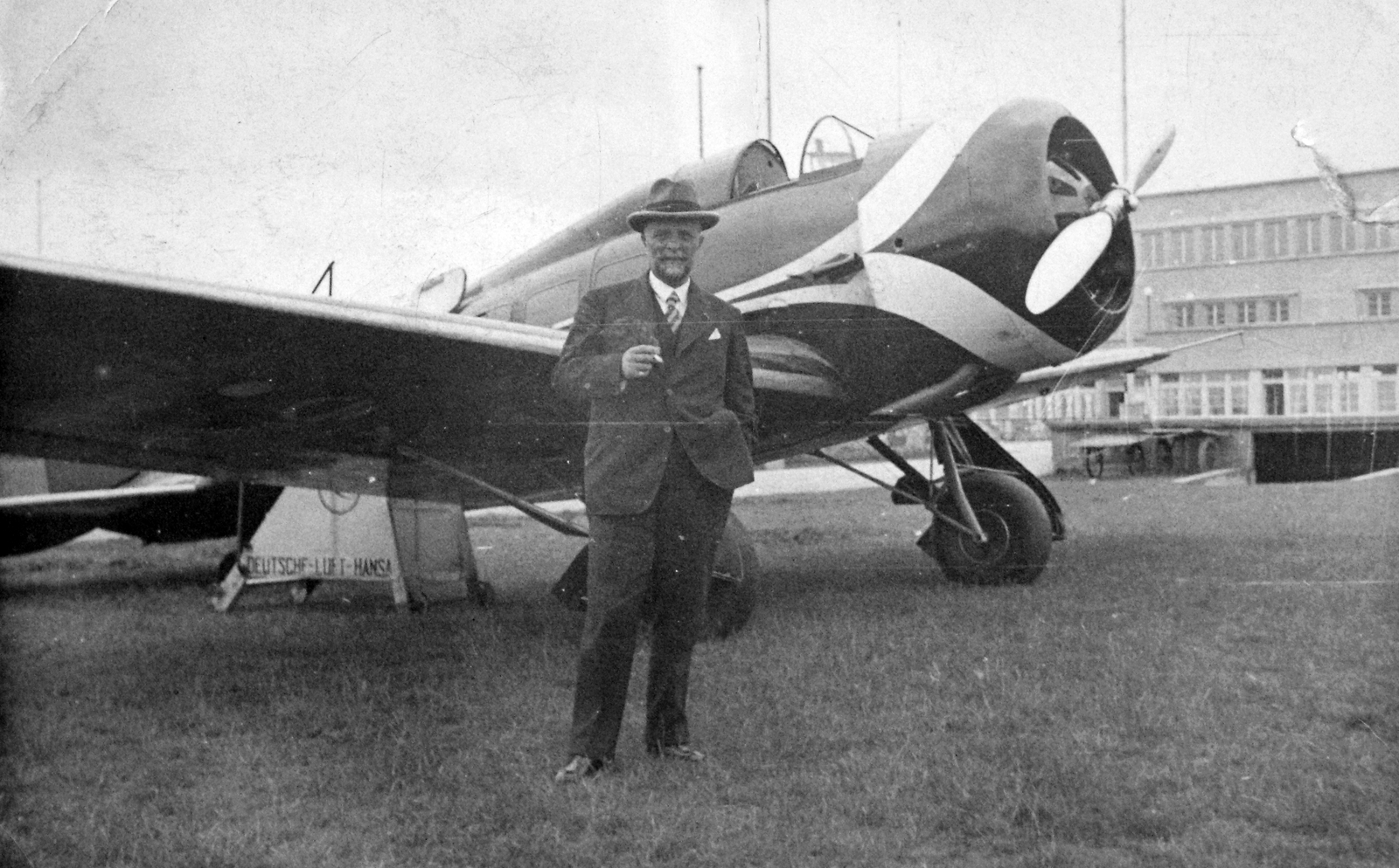 Germany, Munich, Oberwiesenfeld repülőtér. A Swissair svájci légitársaság Lockheed Orion típusú repülőgépe., 1937, Del Medico Imre, portrait, transport, hat, cigarette, smoking, american brand, airplane, man, airport, Lockheed-brand, Swissair airlines, Fortepan #21094