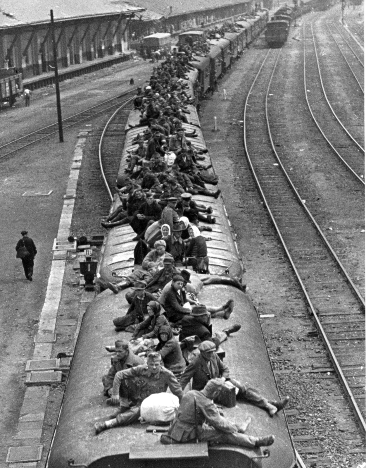 Magyarország, Budapest VI., Nyugati pályaudvar a Ferdinánd hídról a Dózsa György (Aréna) út irányába nézve., 1945, Rózsa László, Budapest, katona, vasúti szerelvény, tetőn ülés, vonat, civil, batyuzás, Fortepan #211063