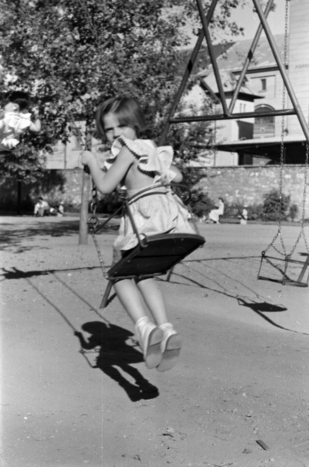 Hungary, Budapest IX., Markusovszky (Úttörő) tér, háttérben az egykori Ferencvárosi Dohánygyár épületei., 1958, Szalai Veronika, Budapest, swing, shadow, swing, looking back, Fortepan #211631