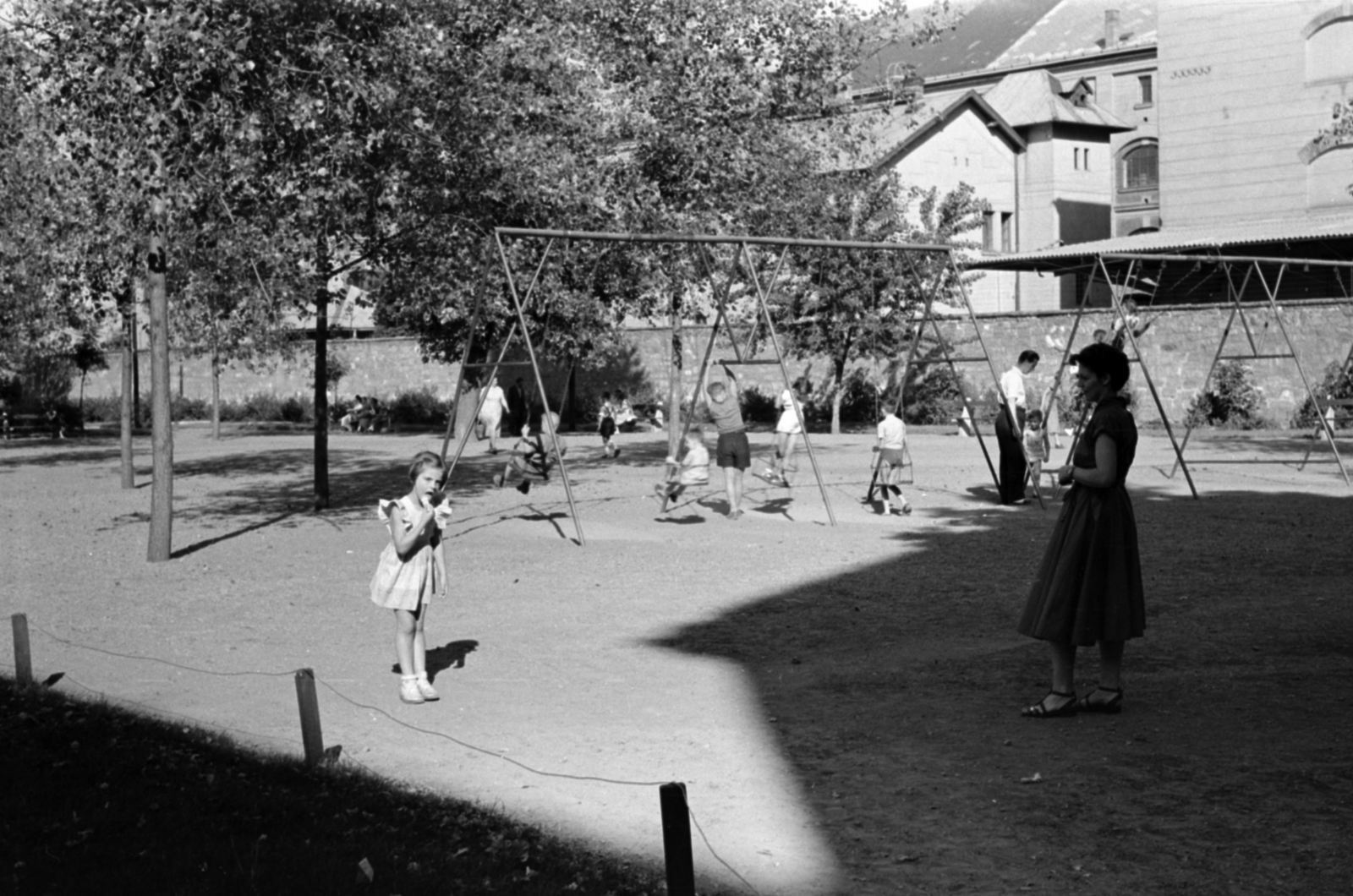 Hungary, Budapest IX., Markusovszky (Úttörő) tér, háttérben az egykori Ferencvárosi Dohánygyár épületei., 1958, Szalai Veronika, Budapest, swing, playground, Fortepan #211636