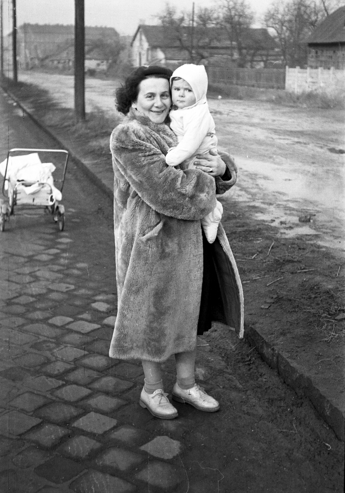 Magyarország, Budapest XIV.,Budapest XIII., Hungária körút a Vidámpark közelében, ma itt a Hungária körút - Róbert Károly körút közötti felüljáró áll. A felvétel bal felső sarkában a Róber Károly körút 104. számú ház látható., 1959, Szolnoki Béla, Budapest, gyerek, kézben tartani, babakocsi, bunda, Fortepan #211852