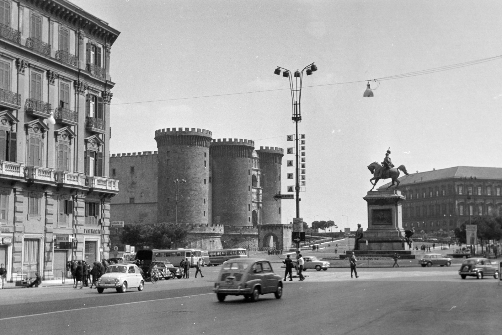 Olaszország, Nápoly, Piazza del Municipio, balra az Új Vár (Castel Nuovo) vagy ismertebb nevén Anjou-erőd (Maschio Angioino), jobbra a II. Viktor Emánuel emlékmű., 1965, Aradi Péter, Szenczi Mária, lovas szobor, Fiat 500, Fortepan #212126