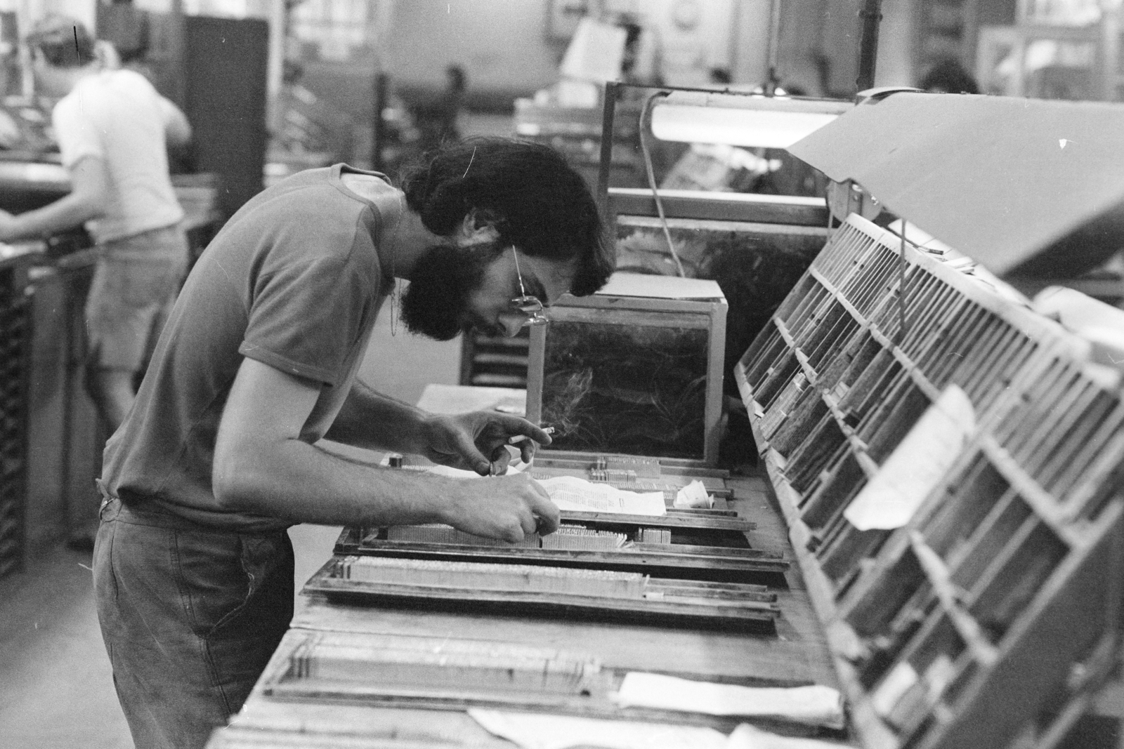 Magyarország, Budapest VII., Osvát utca, Athenaeum Nyomda, szedőterem., 1985, Szalay Zoltán, cigaretta, szakáll, kéziszedő, nyomda, betűszekrény, Budapest, Fortepan #212989