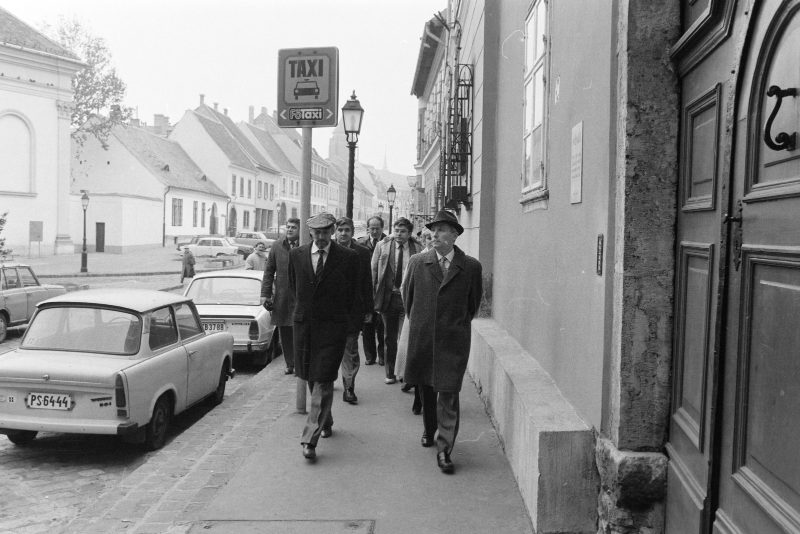 Magyarország, budai Vár, Budapest I., Bécsi kapu tér, balra a Budavári Evangélikus templom, szemben a Fortuna utca. Előtérben balra Zágon Bertalan, a kerületi tanács elnöke, jobbra Lázár György miniszterelnök, tőle takarva mögötte dr.Fehér Józsefné, a kerületi pártbizottság első titkára. A felvétel a miniszterelnök I. kerületi látogatása alkalmával, 1986. december 9-én készült., 1985, Szalay Zoltán, rendszám, Budapest, Fortepan #213096