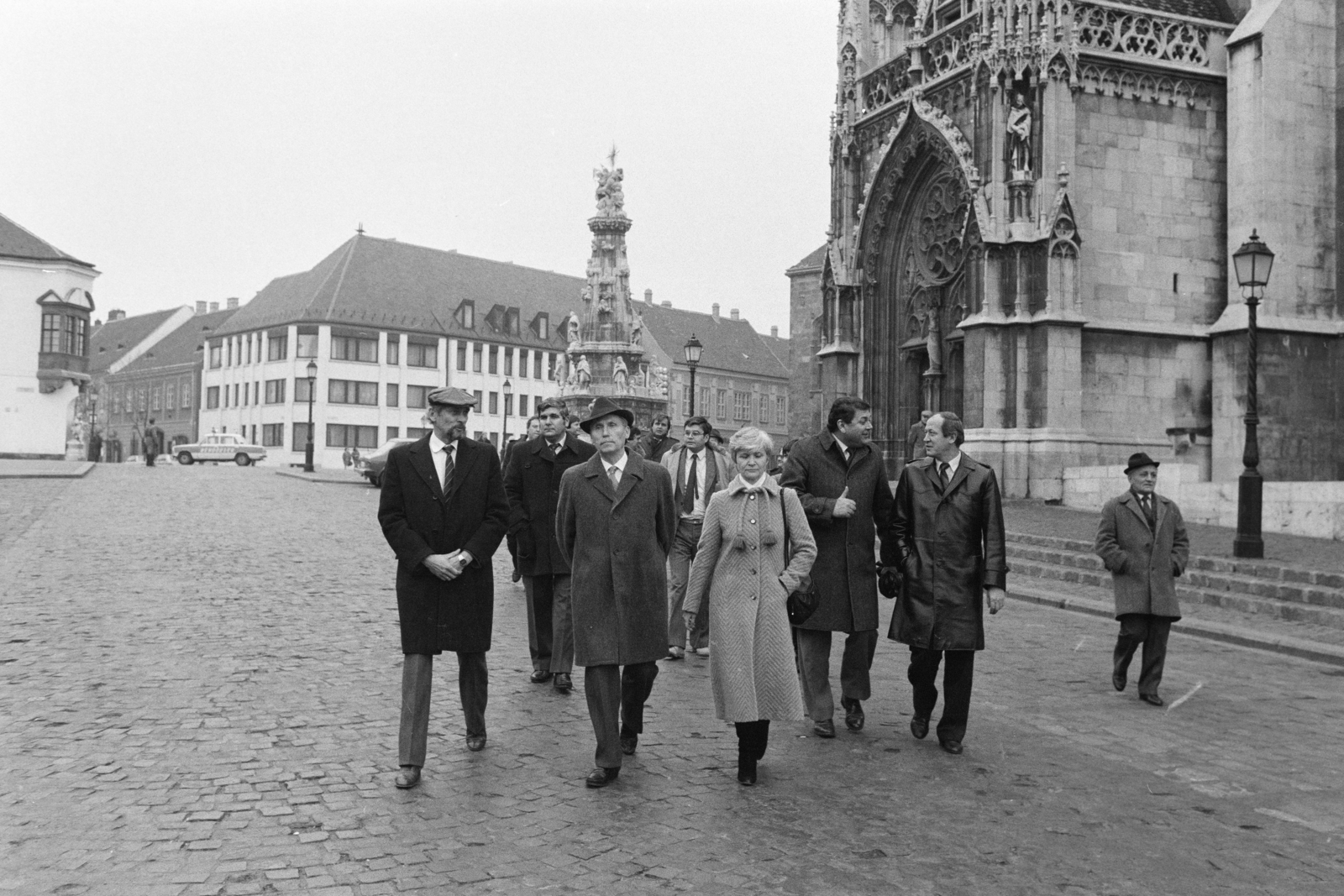 Magyarország, budai Vár, Budapest I., Szentháromság tér, háttérben balra a Tárnok utca - Szentháromság utca sarkán a régi budai városháza, a Szentháromság-szobor, jobbra a Mátyás-templom. Előtérben középen Lázár György miniszterelnök, balra Zágon Bertalan, a kerületi tanács elnöke, jobbra dr.Fehér Józsefné, a kerületi pártbizottság első titkára. A felvétel a miniszterelnök I. kerületi látogatása alkalmával, 1986. december 9-én készült., 1985, Szalay Zoltán, Budapest, Fortepan #213098