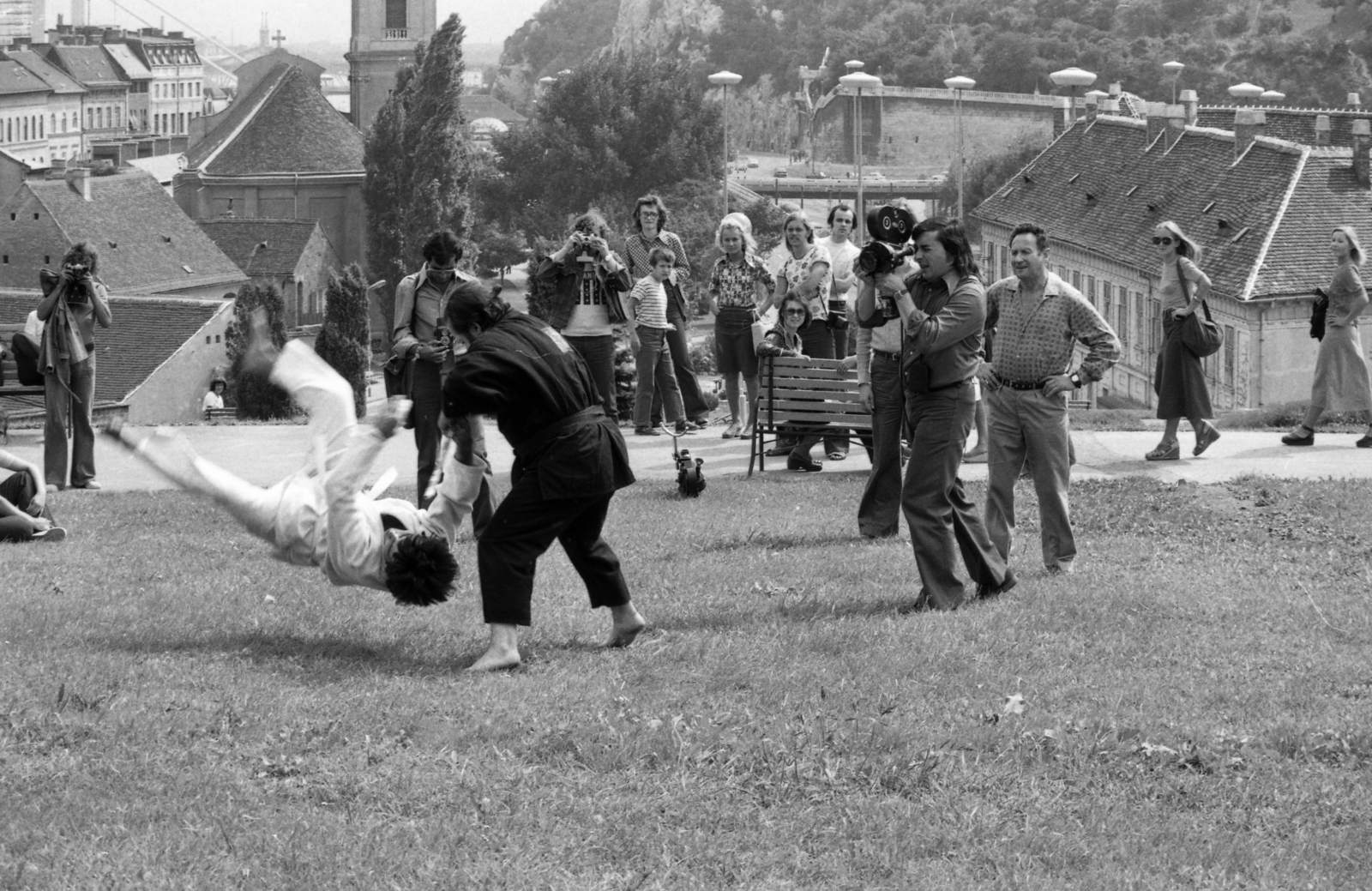 Hungary, Budapest I., a Szarvas tér fölötti park. Jobb oldalon a Szarvas-ház, bal oldalon az Alexandriai Szent Katalin-templom. A felvétel Polyák Józsefről és kaszkadőrcsapatáról készített híradófilm forgatásakor készült. Kockás ingben a rendező Borsodi Ervin., 1975, Urbán Tamás, Budapest, Fortepan #213168