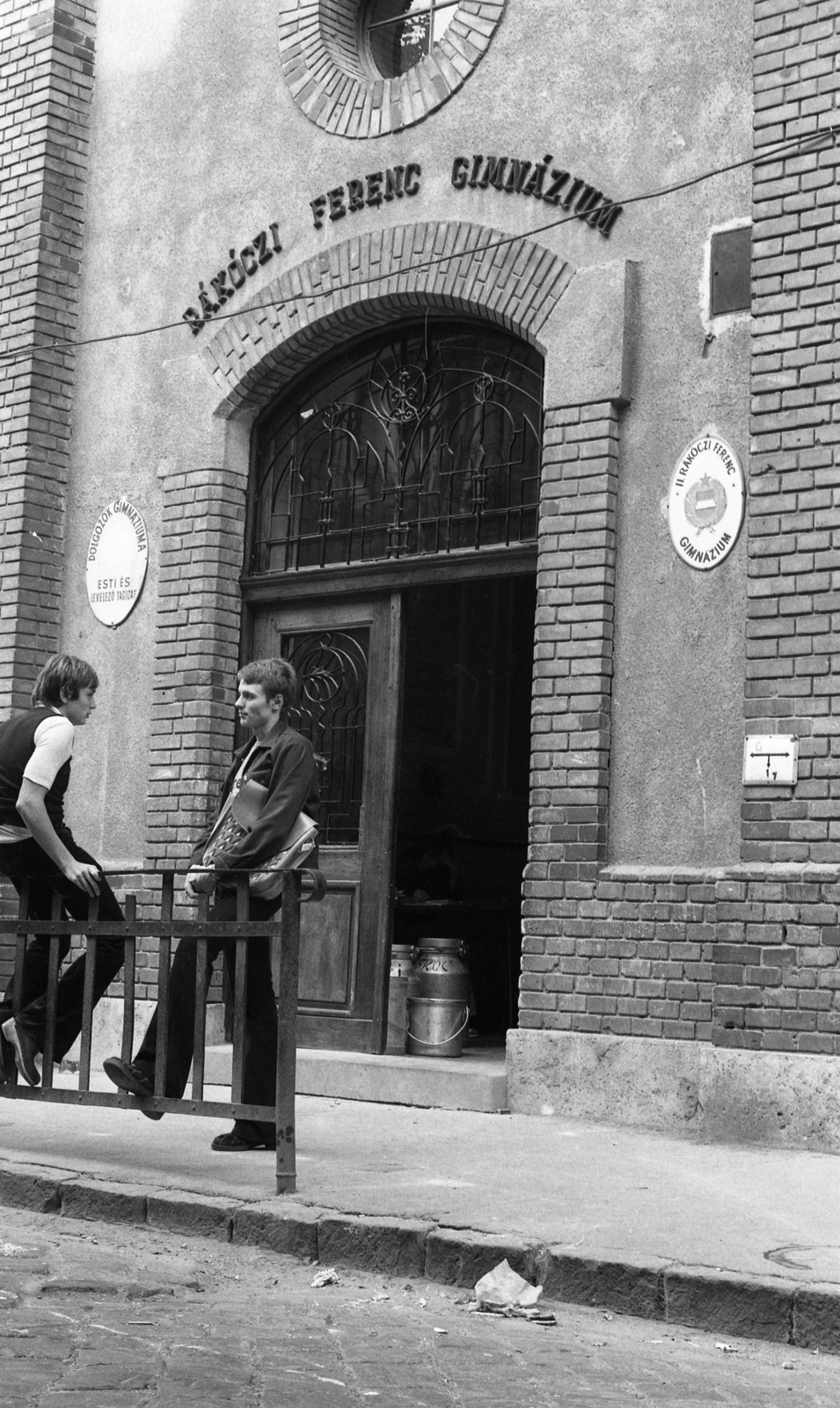 Magyarország, Budapest II., Keleti Károly utca 37., II. Rákóczi Ferenc Gimnázium. A kapu előtt Verrasztó Zoltán és Hargitay András úszó., 1975, Urbán Tamás, iskola, úszás, korlát, címer, tejeskanna, Budapest, Fortepan #213185