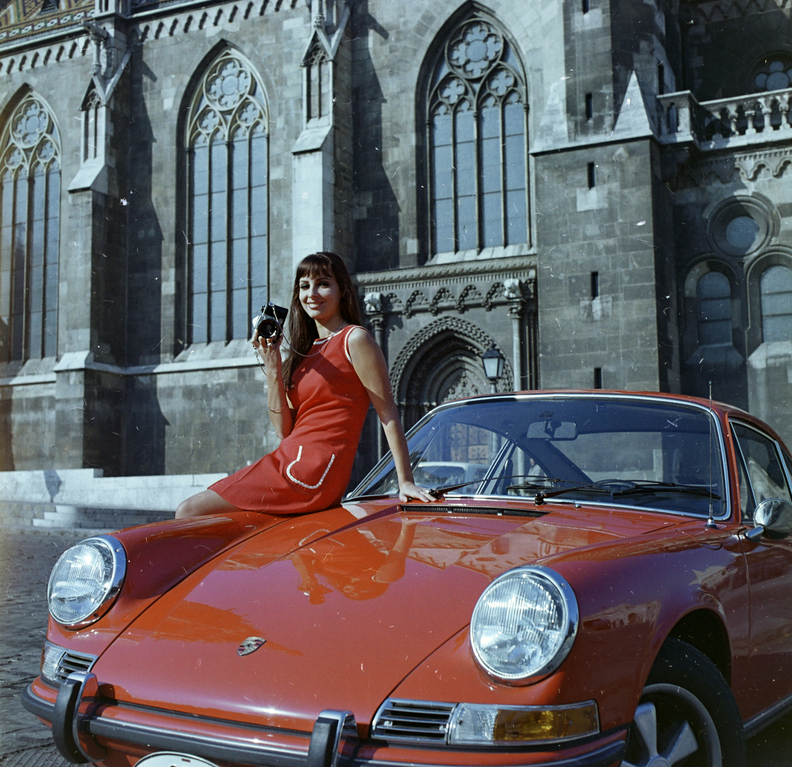 Magyarország, budai Vár, Budapest I., Szentháromság tér, háttérben a Mátyás-templom. Vellai Zsuzsanna manöken., 1970, FŐFOTÓ, színes, Porsche-márka, Porsche 911, Budapest, lányok-járművek, autón ülni, fényképezőgép, nő, templom, Fortepan #214783