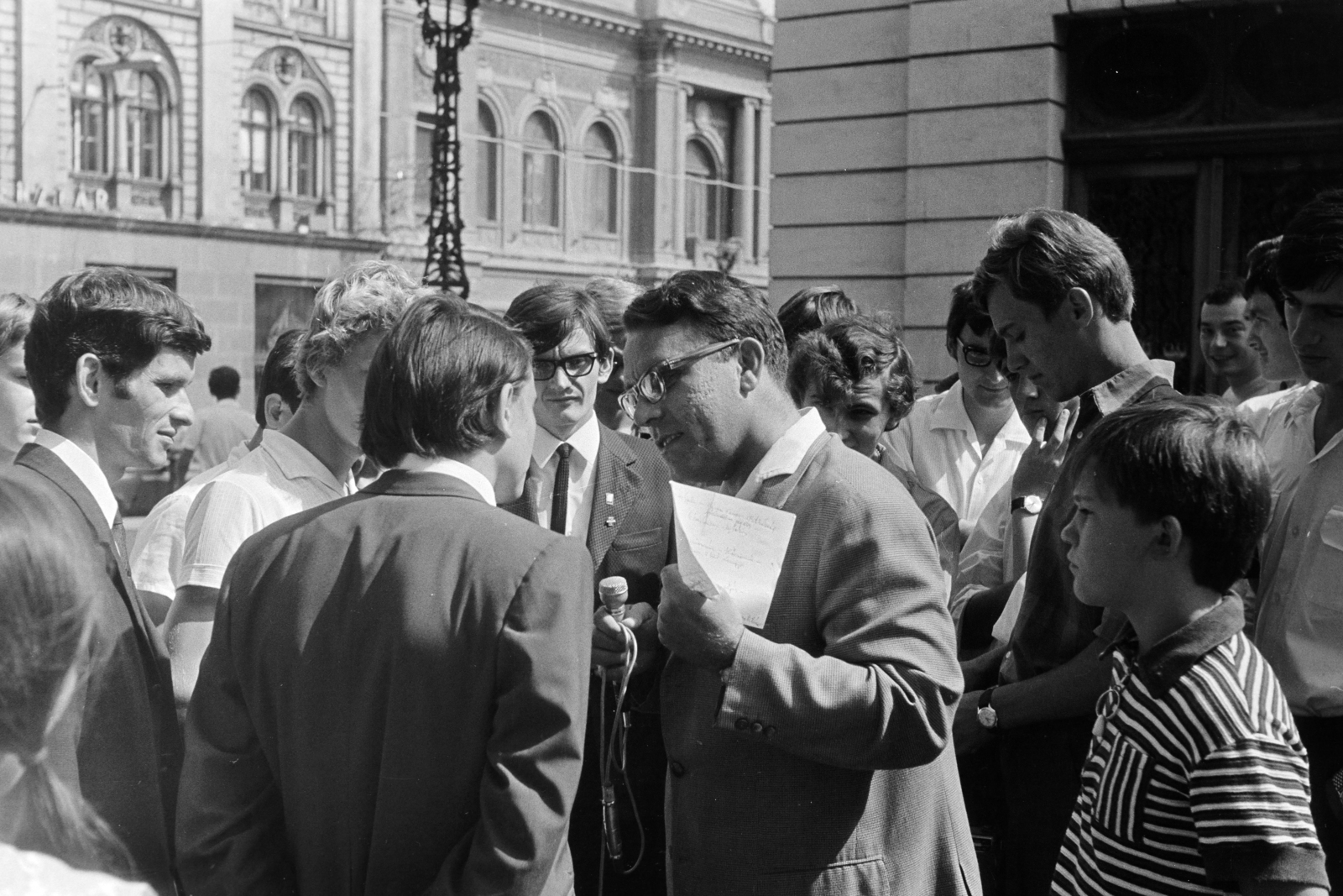Hungary, Pécs, Színház tér, a felvétel a Nemzeti Színház mellett készült, mikrofonnal a kezében Vajek Róbert a Magyar Rádió riportere. Háttérben jobbra a Király (Kossuth Lajos) utca 13., az egykori Nemzeti Kaszínó épülete., 1970, Gothár Péter, Fortepan #216781