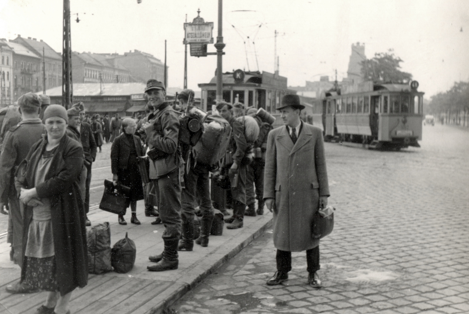 Hungary, Budapest VIII., Fiumei út a Magdolna utca - Salgótarjáni utca közötti villamos kereszteződésnél. Háttérben balra a Dobozi utcai házsor, szemben az OTI székház., 1944, Mihályi Balázs, German soldier, Budapest, Best of, man, suit, coat, tram, tram stop, Fortepan #217814