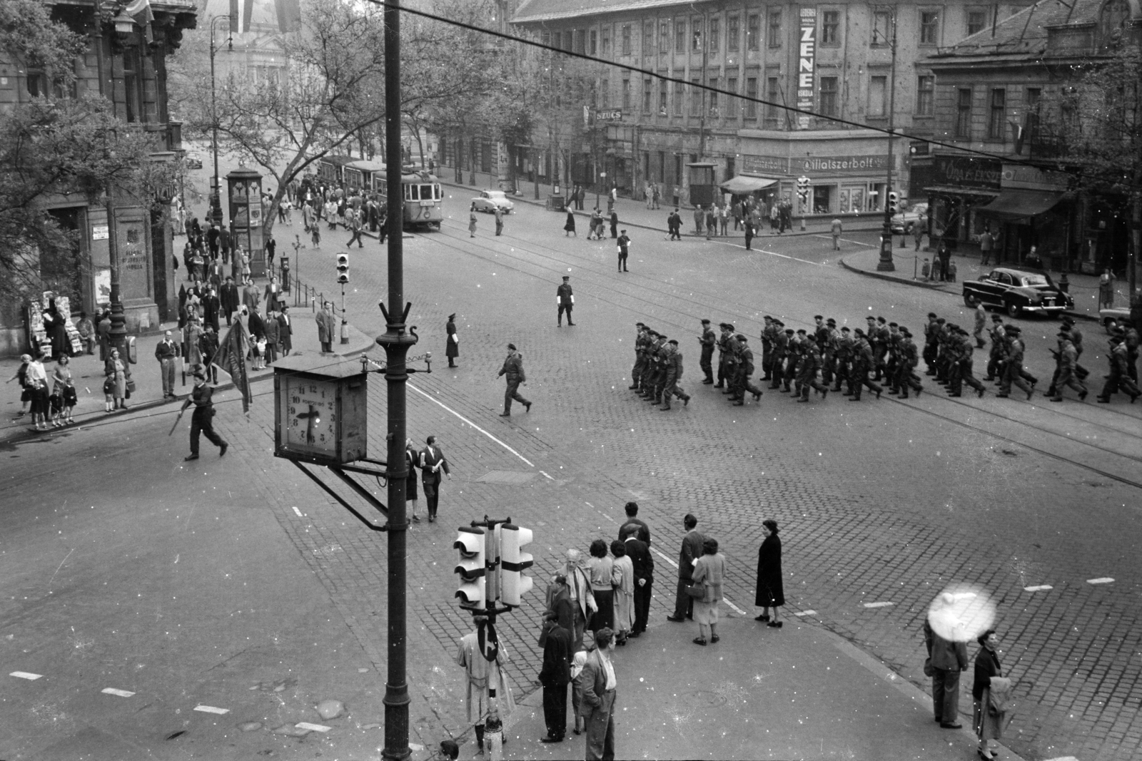 Magyarország, Budapest V.,Budapest VI., Bajcsy-Zsilinszky út az Andrássy út (Magyar Ifjúság útja) saroktól a Deák Ferenc tér felé nézve. Május 1-i felvonuláson és nagygyűlésen résztvevő munkásőrök., 1957, BL, Budapest, köztéri óra, gyalogátkelő, jelzőlámpa, Fortepan #218187