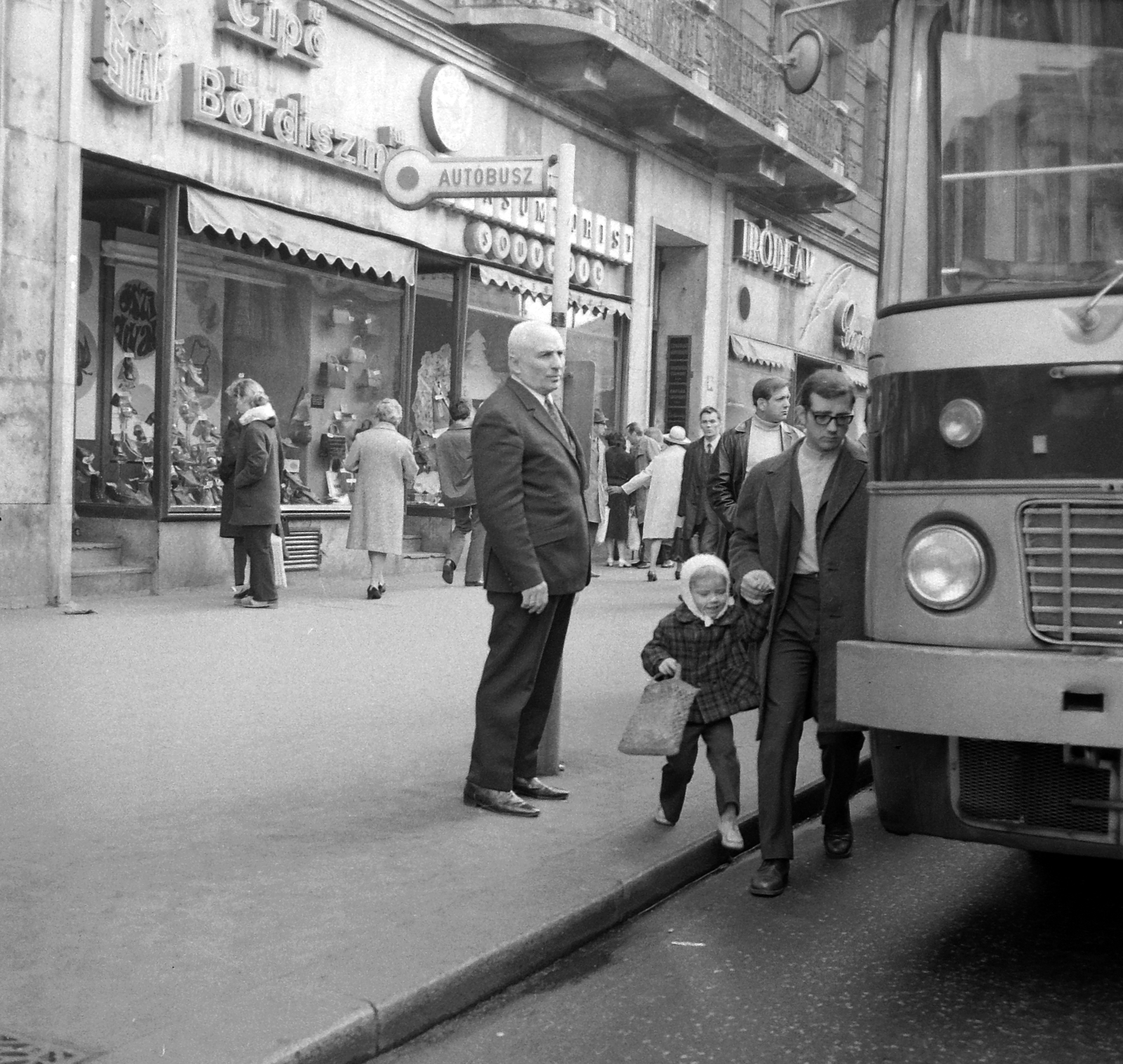 Hungary, Budapest VII., Erzsébet (Lenin) körút, első háztömb a páratlan oldalon, Alfonzó (Markos József) a buszmegállóban., 1971, Kotnyek Antal, art of theater, Show window, bus, Hungarian brand, neon sign, Ikarus-brand, bus stop, actor, shoe store, Budapest, rear-view mirror, Fortepan #21844