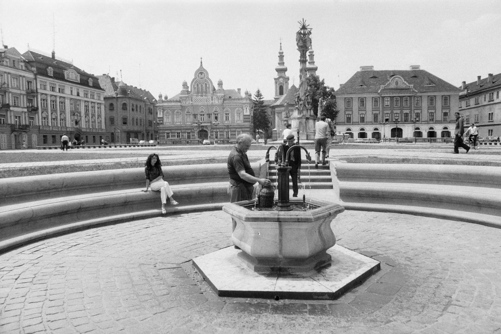 Romania,Transylvania, Timisoara, Losonczy tér (más néven Dóm tér, Piața Unirii), ásványvizes kút. Középen a pestisjárvány megszűntének emlékére 1740-ben emelt Szentháromság-szobor. Szemben a szerb ortodox püspökség palotája, ettől jobbra a katedrálisa és az egyházközösség épülete., 1983, Dőri András, Fortepan #218601