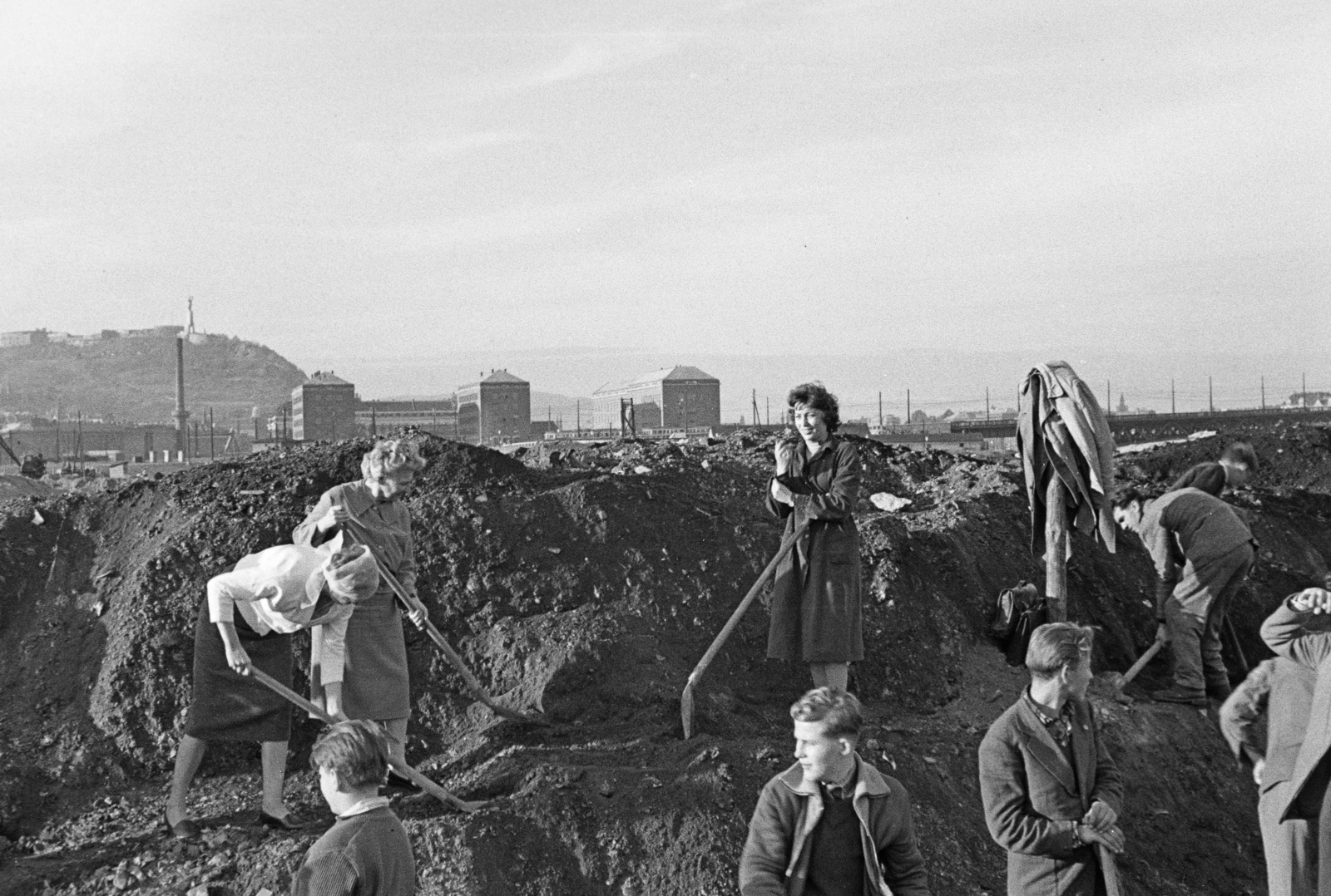 Hungary, Budapest XI., parképítés a Petőfi híd budai hídfőjétől délre (később itt az ELTE és a BME épületei állnak). Háttérben a Budapesti Műszaki Egyetem (később Budapesti Műszaki és Gazdaságtudományi Egyetem) épületei és kazántelepének (mára visszabontott) kéménye, valamint a Gellért-hegy., 1964, Krantz Károly, volunteering, shovel, Budapest, Fortepan #219198