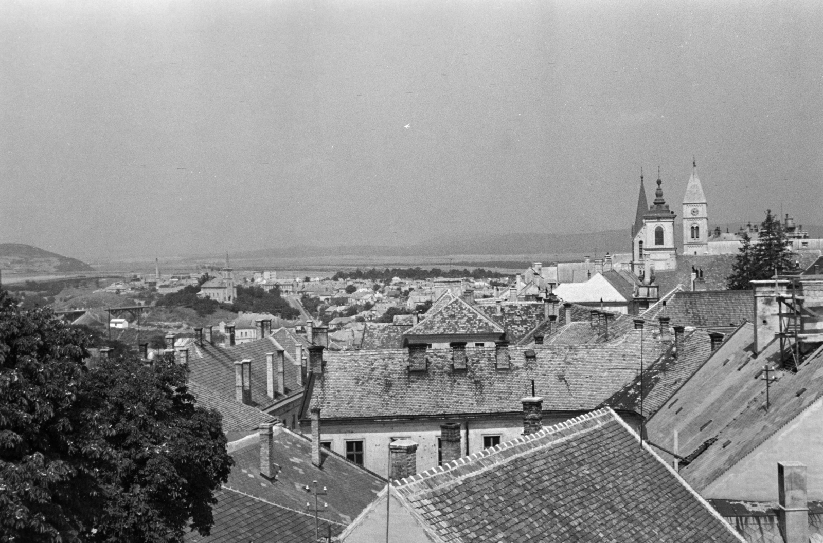Magyarország, Veszprém, kilátás a Tűztoronyból a Szent István völgyhíd (Völgyhíd / Viadukt) és a Szent László-templom felé. A Vár épületei felett a Szent István ferences templom, a Piarista templom és Szent Mihály-székesegyház tornya látszik., 1960, Krantz Károly, háztető, Fortepan #219327