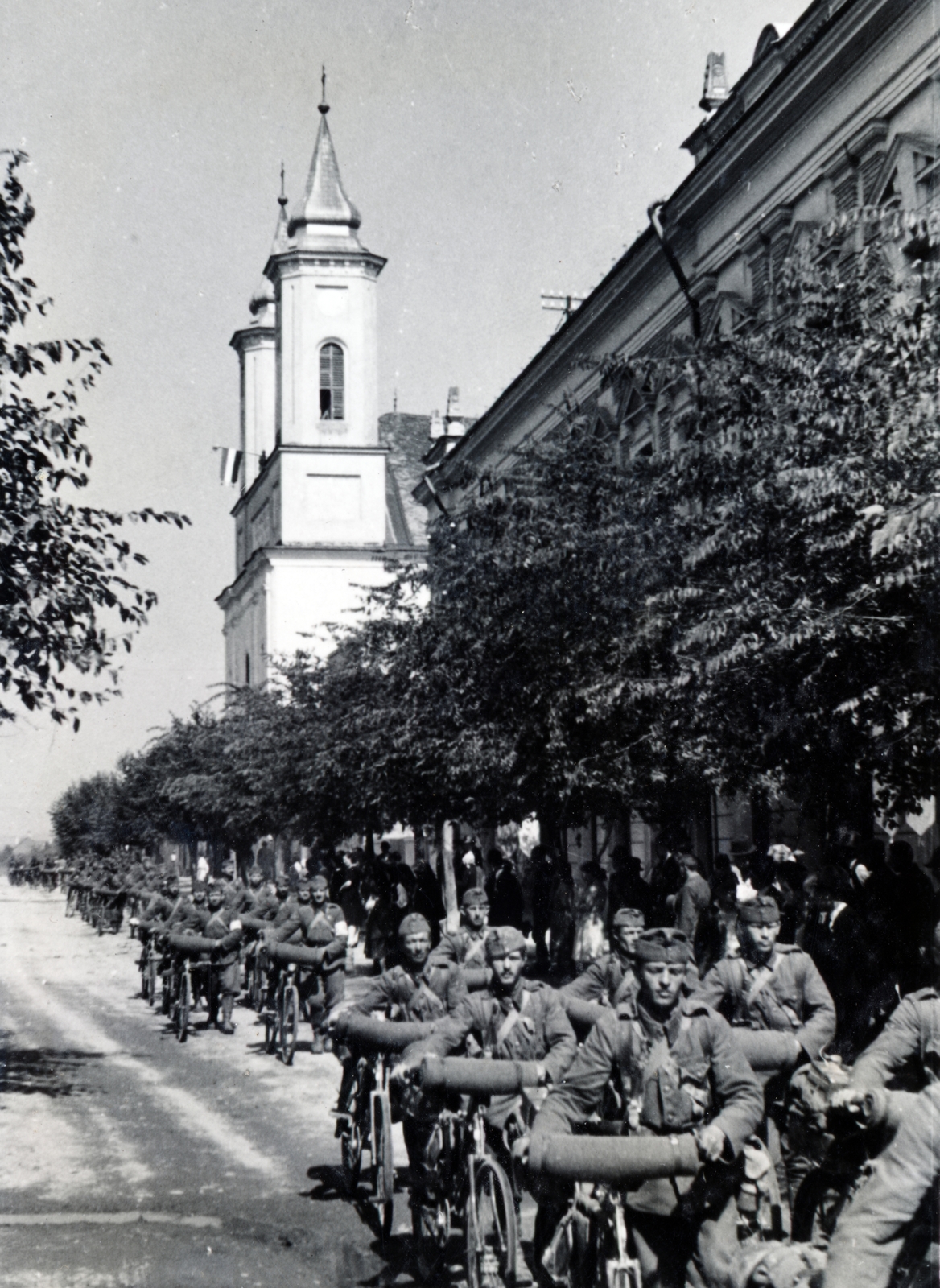 Romania,Transylvania, Gherla, Strada Bobâlna, jobbra a Ferences templom és az egykori Hitelbank épülete (később Polgármesteri Hivatal). A felvétel 1940. szeptember 9-én, a magyar csapatok bevonulása idején készült., 1940, Kádár Attila, bicycle, church, conscription, Fortepan #220417