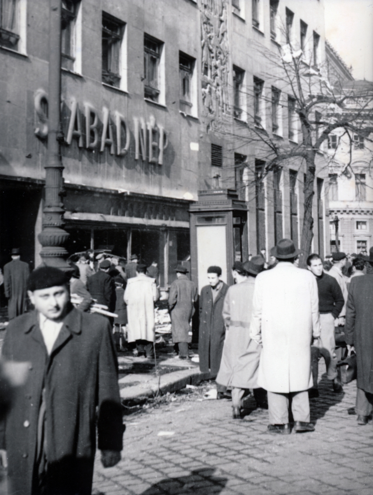 Hungary, Budapest VIII., József körút, a felvétel a Szabad Nép könyvesboltja előtt készült. A székház mögött a Nemzeti Színház épületének részlete látszik., 1956, Matthaeidesz Konrád, revolution, ad pillar, beret, Budapest, Fortepan #221644