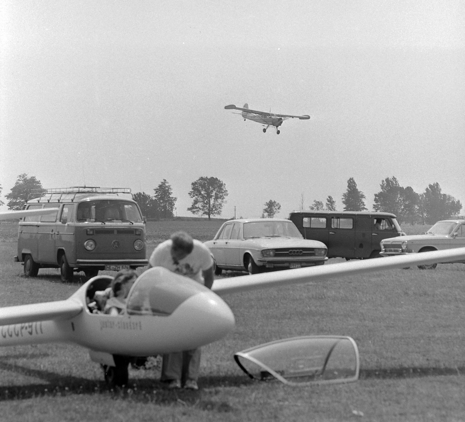 Magyarország, Dunaújváros, Kisapostagi sportrepülõtér, I. Nõi Vitorlázórepülõ Európa Bajnokság. A PZL-101 Gawron repülőgép leszáll, előtérben egy SZU vitorlázó repülőgép., 1979, MHSZ, sport, közlekedés, német gyártmány, szovjet gyártmány, GAZ-márka, repülőgép, Volkswagen-márka, Audi-márka, repülőtér, PZL-márka, lengyel gyártmány, vitorlázó repülőgép, GAZ 24 Volga, SZD-márka, SZD-41 Jantar Standard, Volkswagen Typ2, Audi 100, Fortepan #22180