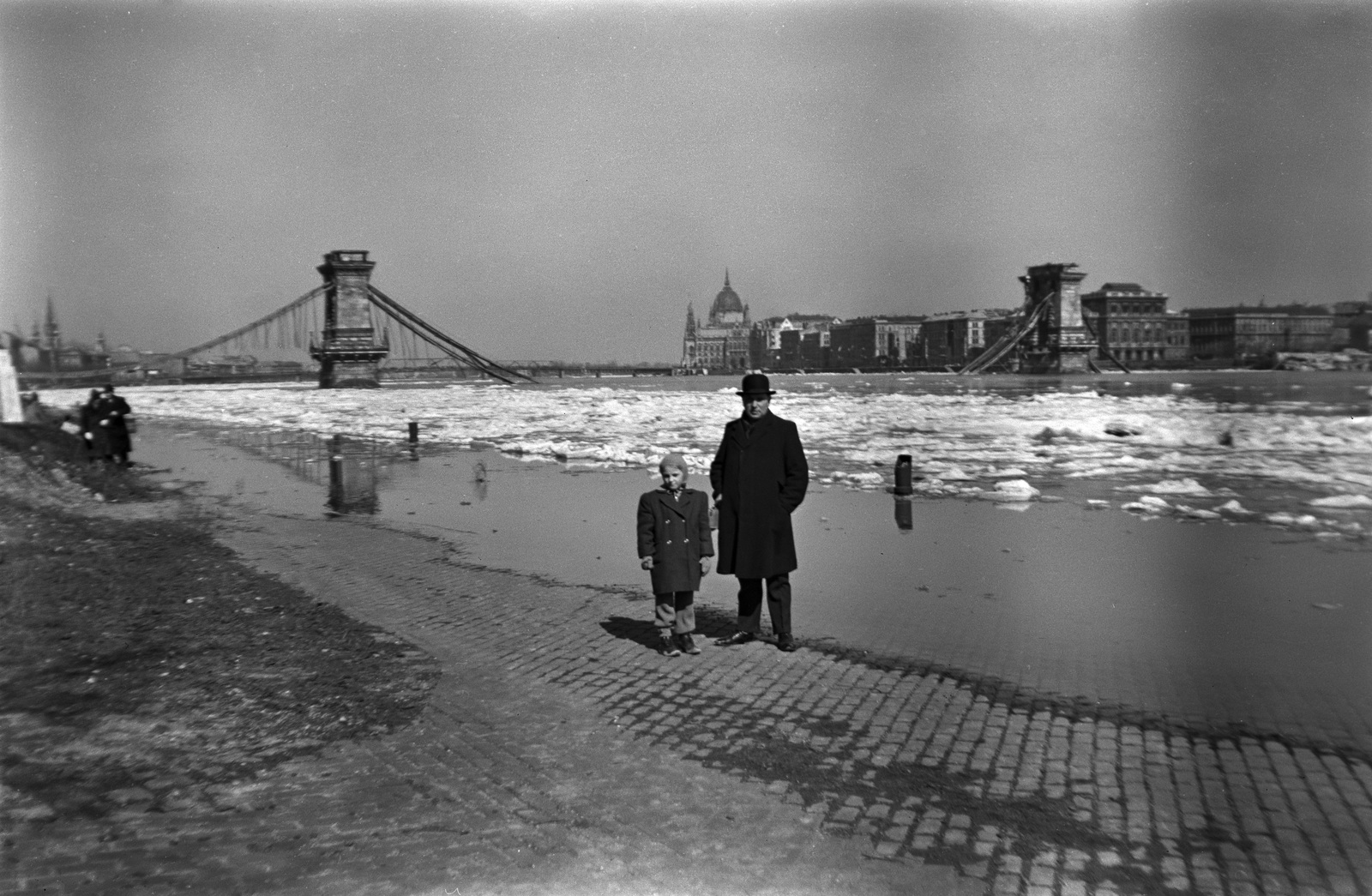 Magyarország, Budapest I., budai alsó rakpart, a lerombolt Széchenyi Lánchíd, háttérben a Kossuth híd és Parlament., 1946, Fortepan/Album002, gyermek, tél, folyó, árvíz, hídroncs, férfi, rakpart, Duna, jégzajlás, Budapest, függőhíd, William Tierney Clark-terv, Fortepan #22227