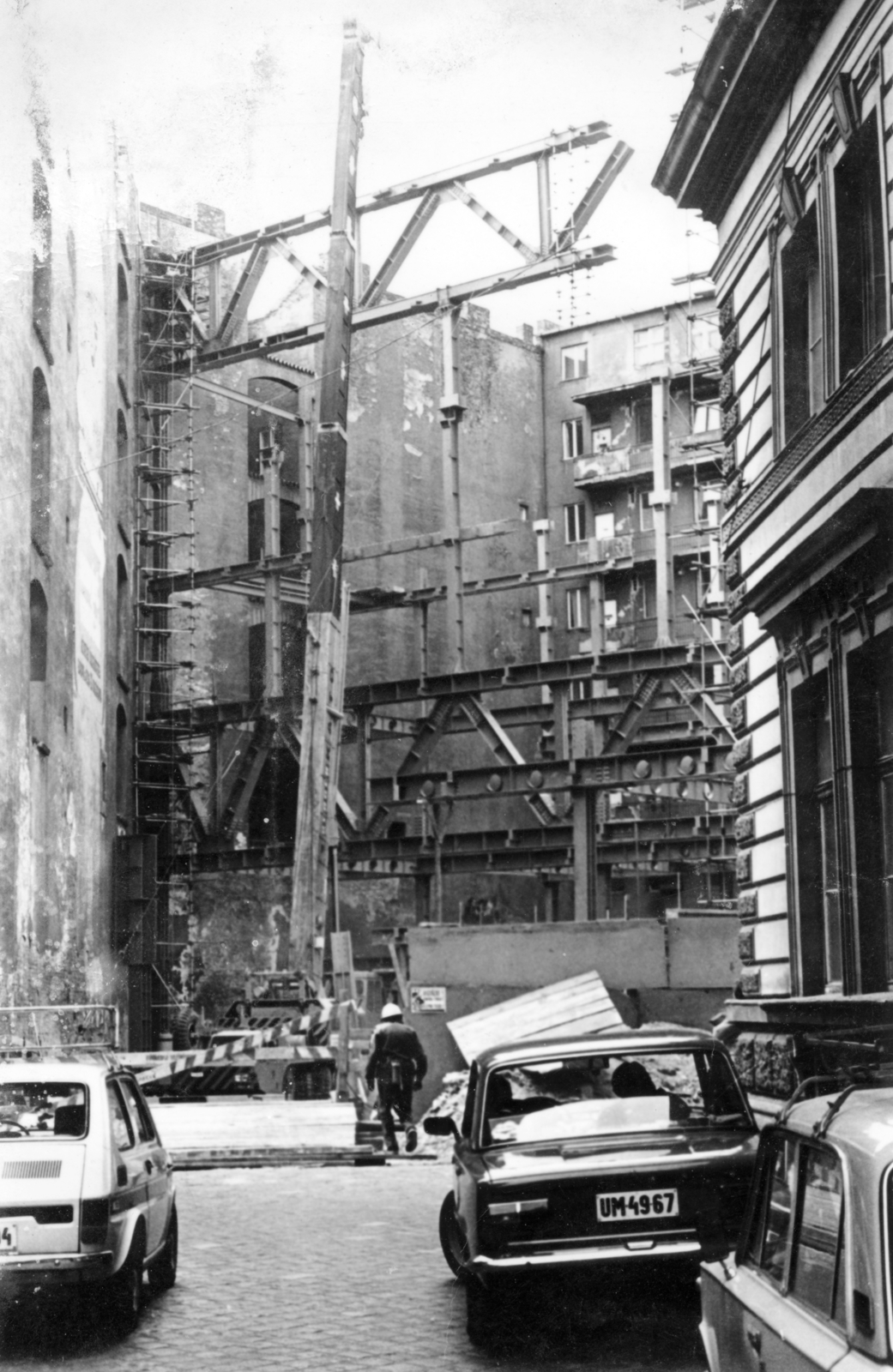 Magyarország, Budapest VI., Nyugati (Marx) tér, szemben a Skála Metró nagyáruház építkezése. Balra a Jókai utca 40. számú ház tűzfala, jobbra az egykori indóházból kialakított MÁV BVKH / Bevételellenőrzési, Visszatérítési és Kártérítési Hivatalának részlete látható., 1979, Középületépítő Vállalat - Kreszán Albert - Koczka András - Kemecsei József, rendszám, bevásárlóközpont, Budapest, Fortepan #223677