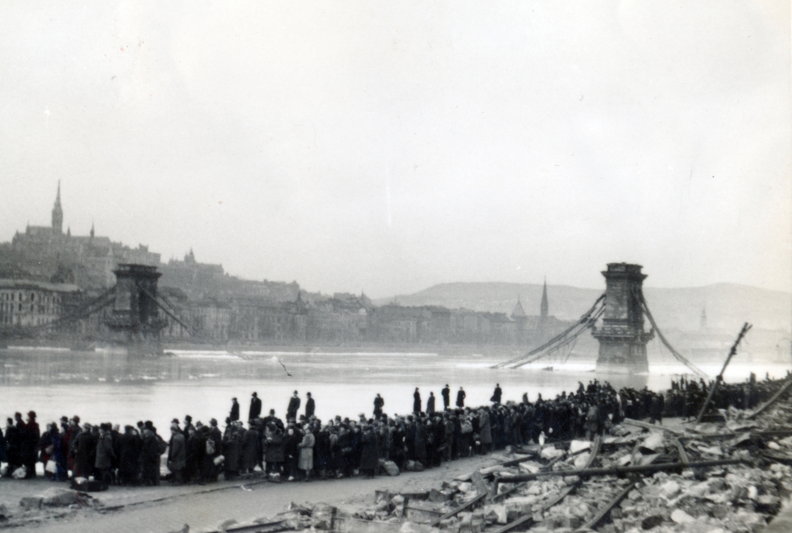 Hungary, Budapest V., pesti alsó rakpart, dunai átkelésre várók sora, háttérben a lerombolt Széchenyi Lánchíd., 1945, Kádár Anna, mass, wrecked bridge, picture, standing in line, Budapest, Fortepan #223884