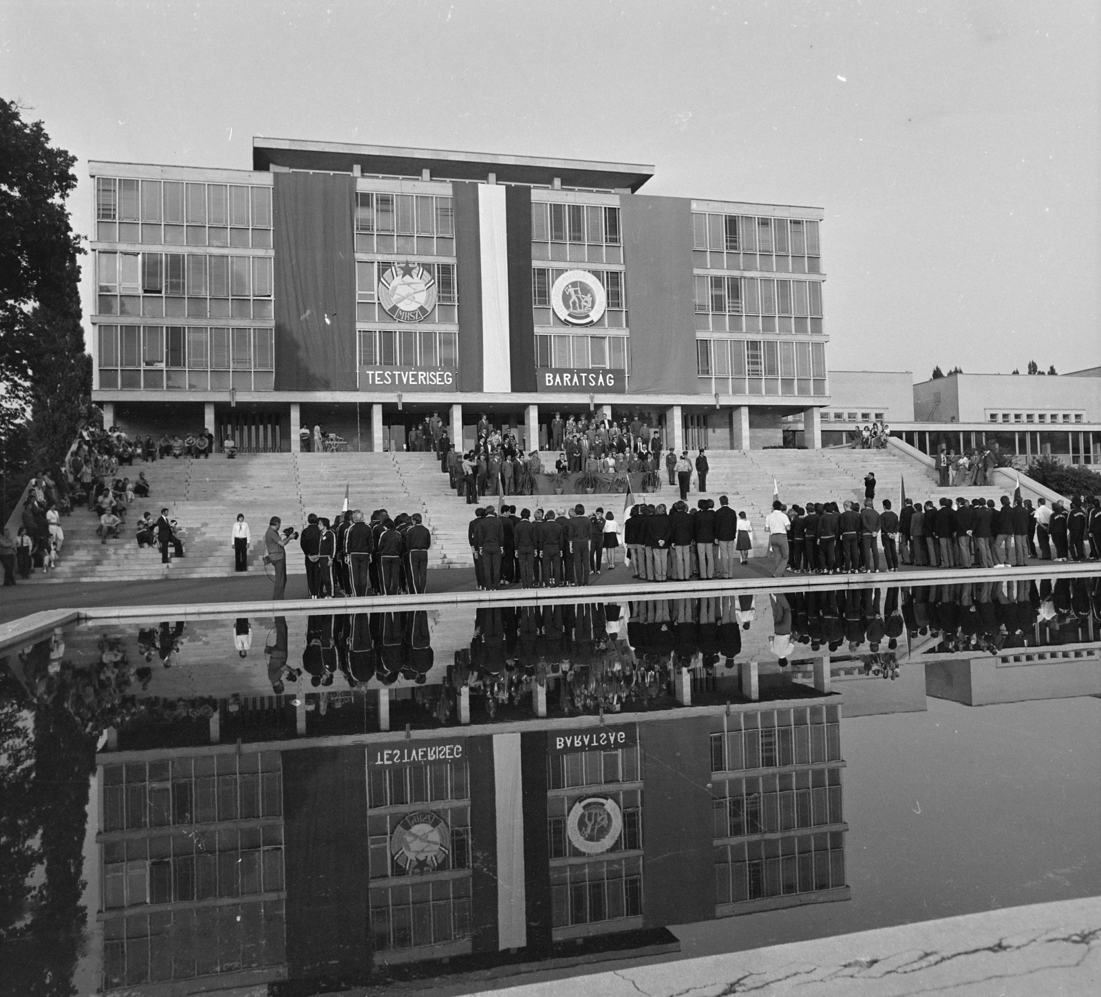 Hungary, Gödöllő, Gödöllői Agrártudományi Egyetem (később Szent István, majd Magyar Agrár- és Élettudományi Egyetem), Gépészmérnöki Kar. Testvériség- Barátság elnevezésű nemzetközi honvédelmi verseny résztvevői., 1976, MHSZ, pool, reflection, water surface, festive, crest, building, Fortepan #22419