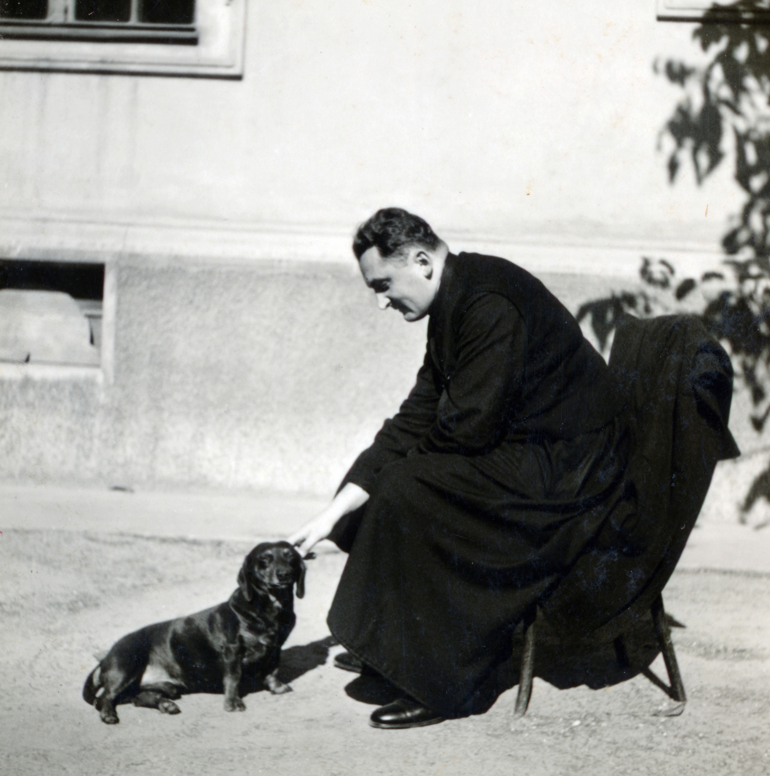 Magyarország, Debrecen, Varga utca 2., a felvétel a Piarista rendház (később Szent József Kollégium) udvarán készült., 1936, Fóris Gábor / Vastagh Miklós hagyatéka, portré, kutya, pap, reverenda, tacskó, Fortepan #226482