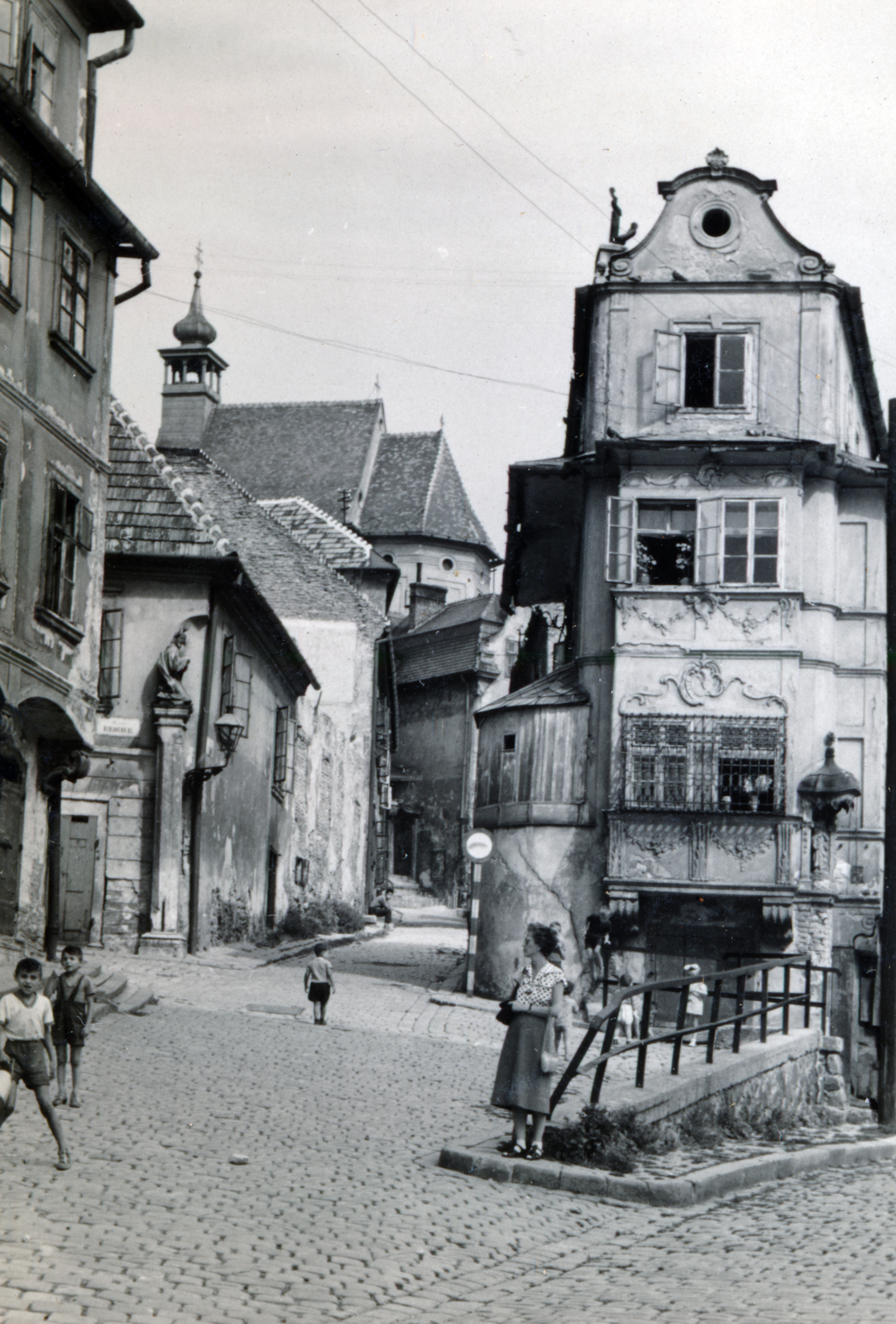 Slovakia, Bratislava, balra a Miklós utca (Mikulášska ulica), jobbra a Vártelek utca (Židovská ulica), a kettő között az un. Jó pásztor háza, nevét a ház sarkán elhelyezett Krisztus szoborról kapta. Háttérben a Szent Miklós-templom., 1956, Flanek-Falvay-Kováts, street view, building statue, Fortepan #229200