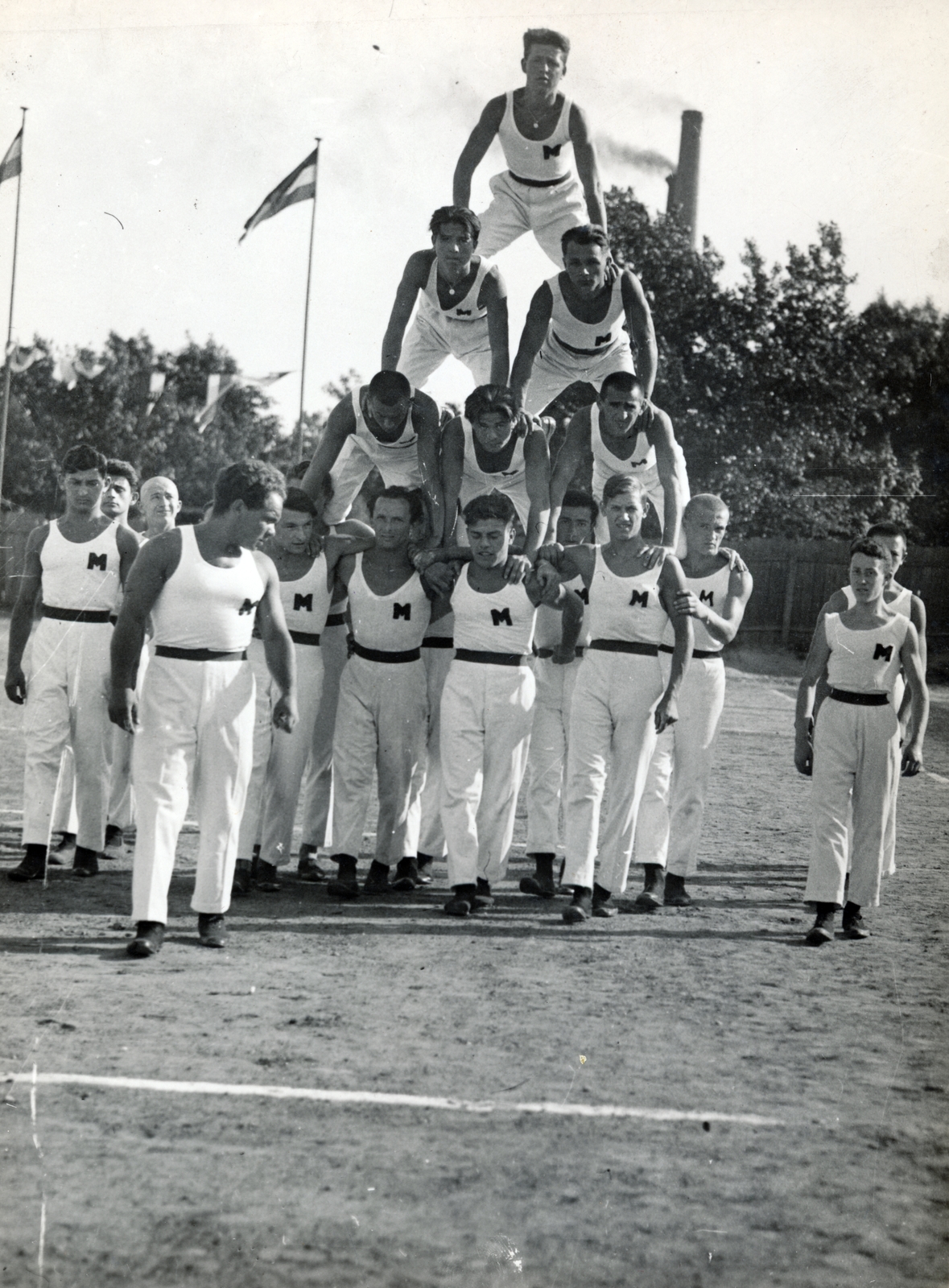 Hungary, Budapest XIII., Újpesti rakpart, tornabemutató a B.T.K. sportpályáján. Háttérben a BSZKRT Révész utcai áramfejlesztő telepének a kéményei láthatók., 1928, Hirsch Hugó, pitch, feat, human pyramid, Budapest, Fortepan #229361