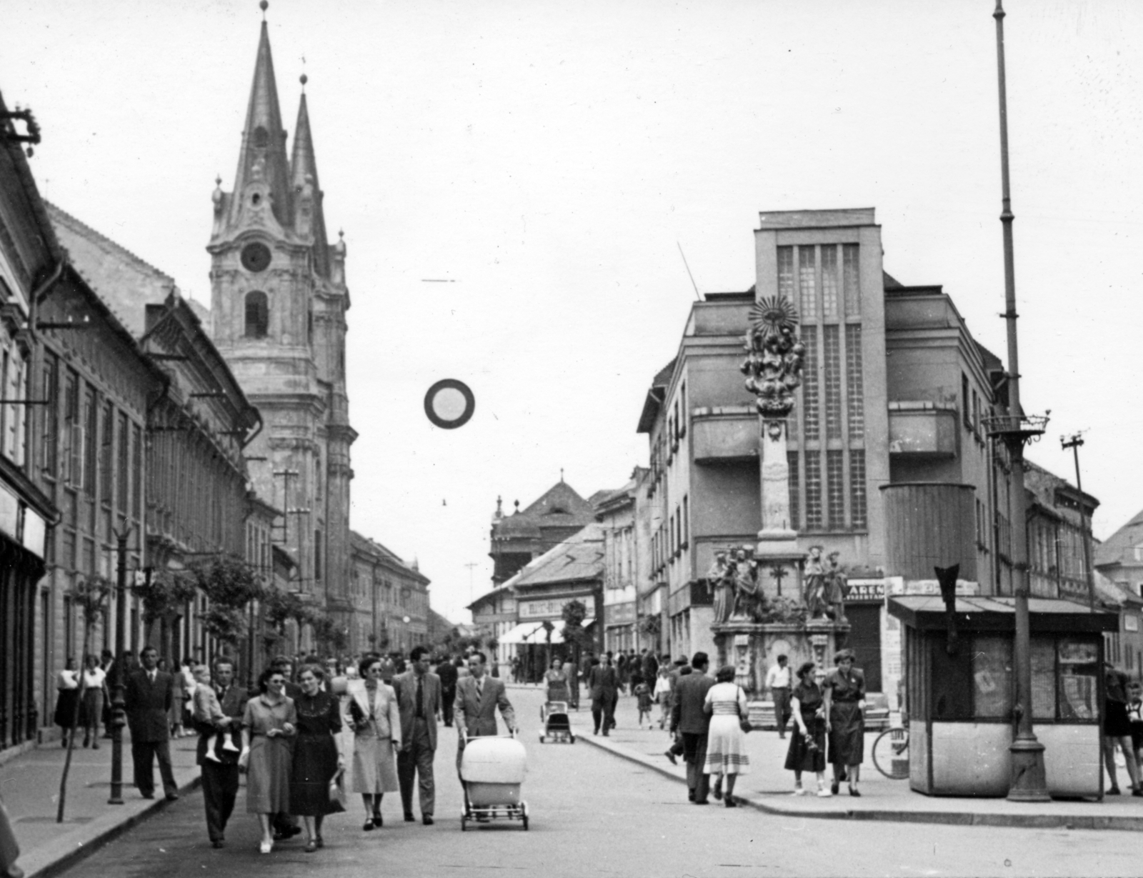 Slovakia, Komarno, Szentháromság-szobor a Klapka György téren (námestie generála Klapku). Balra a Nádor utca (Palatinova ulica) és a Szent András-templom., 1954, Stuber Andrea, street view, pedestrian, baby carriage, church, Holy Trinity Statue, Fortepan #229659