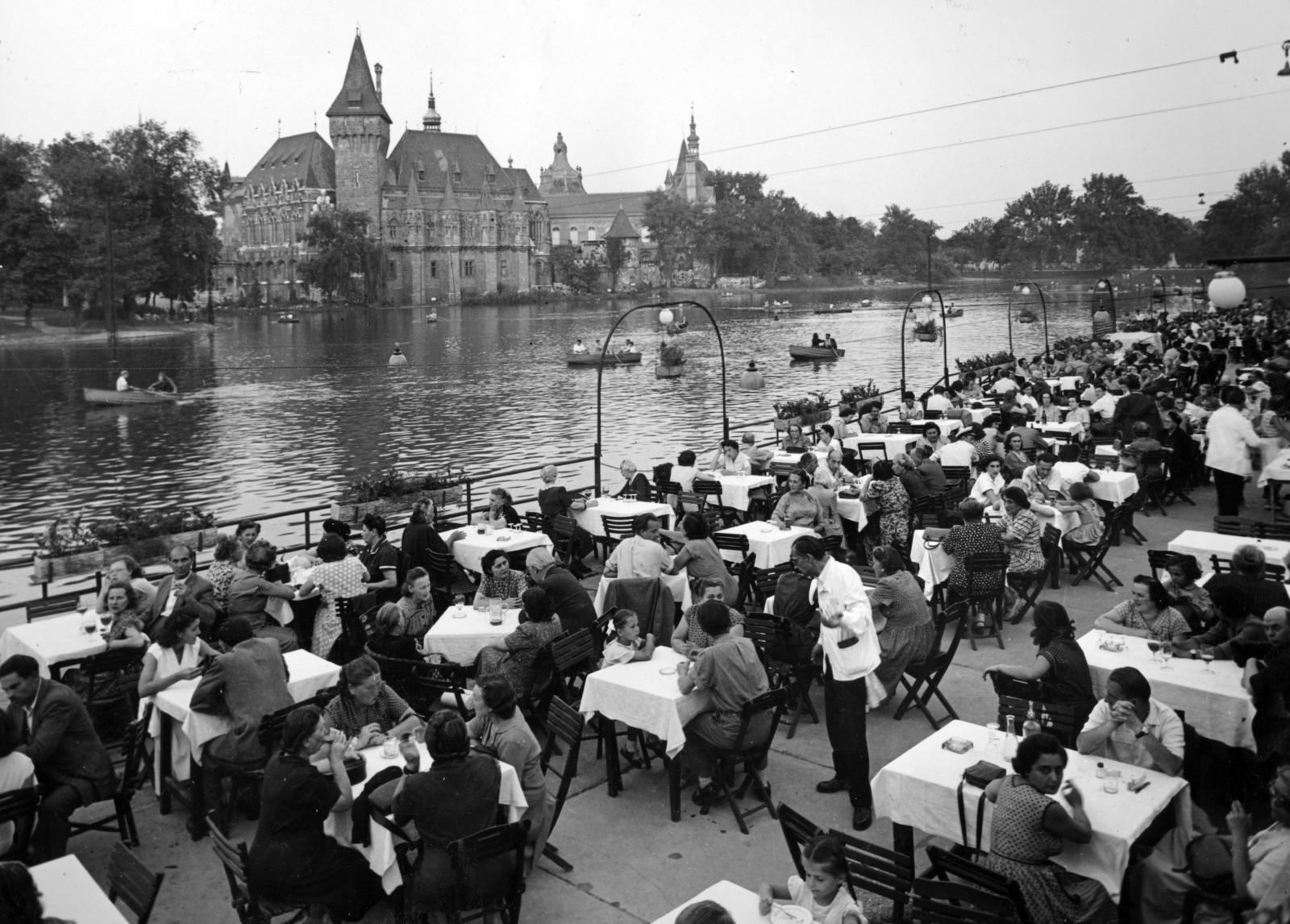 Hungary, Budapest XIV., étterem a műjégpálya épülete előtt, a Városliget.tó túlpartján a Vajdahunyad vára., 1953, Fortepan/Album083, terrace, hospitality, waiter, boating, lake, restaurant, Budapest, Fortepan #229788