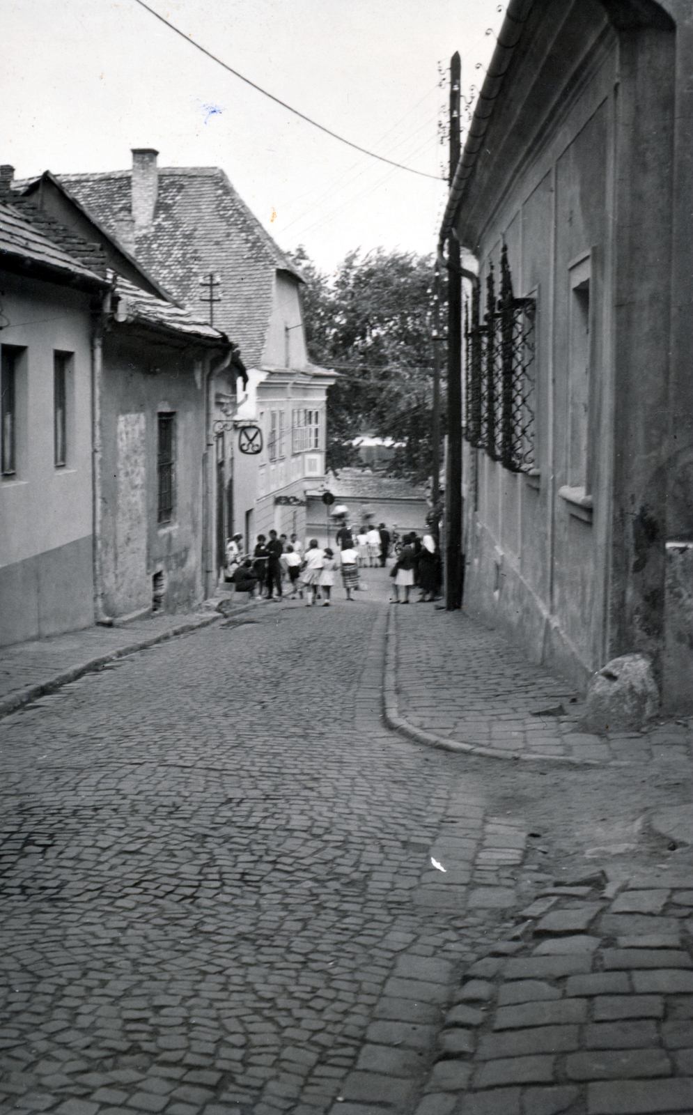 Magyarország, Szentendre, a Görög utca a Duna korzó (Somogyi-Bacsó part) felé nézve., 1965, Kőszeghy Anna, Záborszky Endre, villanyoszlop, cégér, ablakrács, kockakő, Fortepan #230028