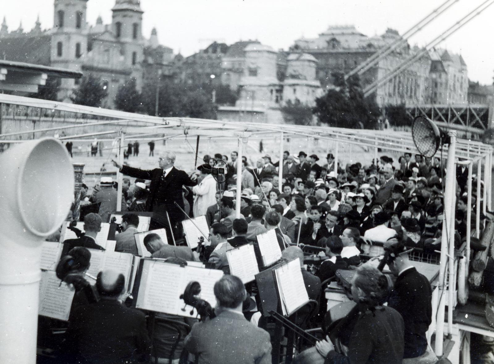 Hungary, Budapest V., hajókikötő a Petőfi térnél. A Székesfővárosi Zenekar hangversenye egy sétahajó fedélzetén, a karmester Bor Dezső. Háttérben a Belvárosi templom és az Erzsébet híd pesti hídfője., 1936, Bor Dezső, conductor, Budapest, Fortepan #231336