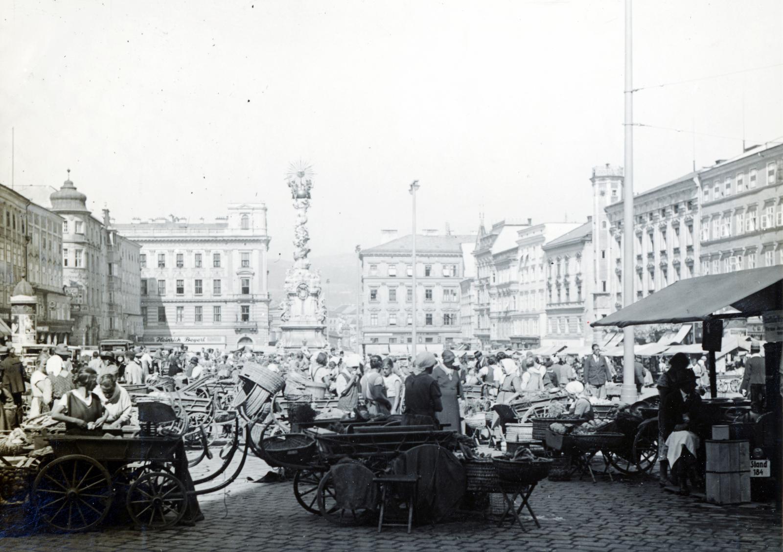 Austria, Linz, Fő tér, piac. Középen a Szentháromság-szobor, jobbra a saroktornyos épület a Régi Városháza (Altes Rathaus), 1933, Bor Dezső, wickerwork, chariot, seller, Fortepan #231351