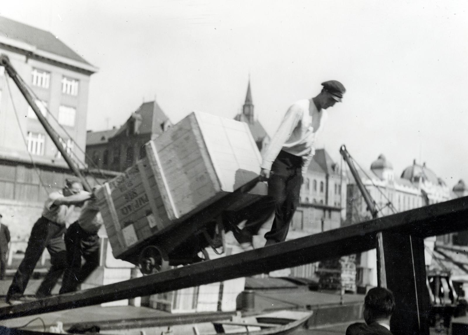 Slovakia, Bratislava, rakodómunkások dolgoznak a Szlovák Nemzeti Múzeum (ekkor Szlovák Honismereti Múzeum) előtti teherhajó-kikötőnél, háttérben a Fémipari Szakiskola (később Gépészeti Szakközépiskola / Stredná priemyselná škola strojnícka) épülete., 1933, Bor Dezső, wheelbarrow, crane, ramp, chest, push starting, port, Fortepan #231374