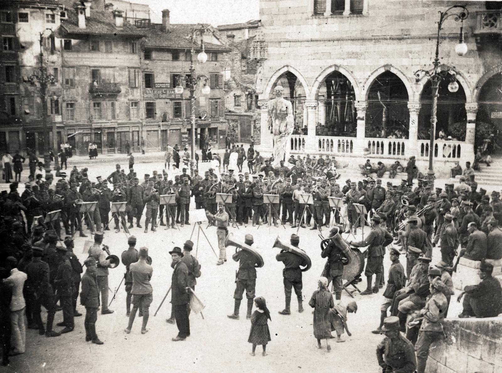 Italy, Udine, Piazza Libertà, a katonai zenekar térzenét ad a Loggia del Lionello előtt, mögöttük középen a Herkules szobor látható., 1918, Bor Dezső, sculpture, military band, music-stand, First World War, public building, Fortepan #231503