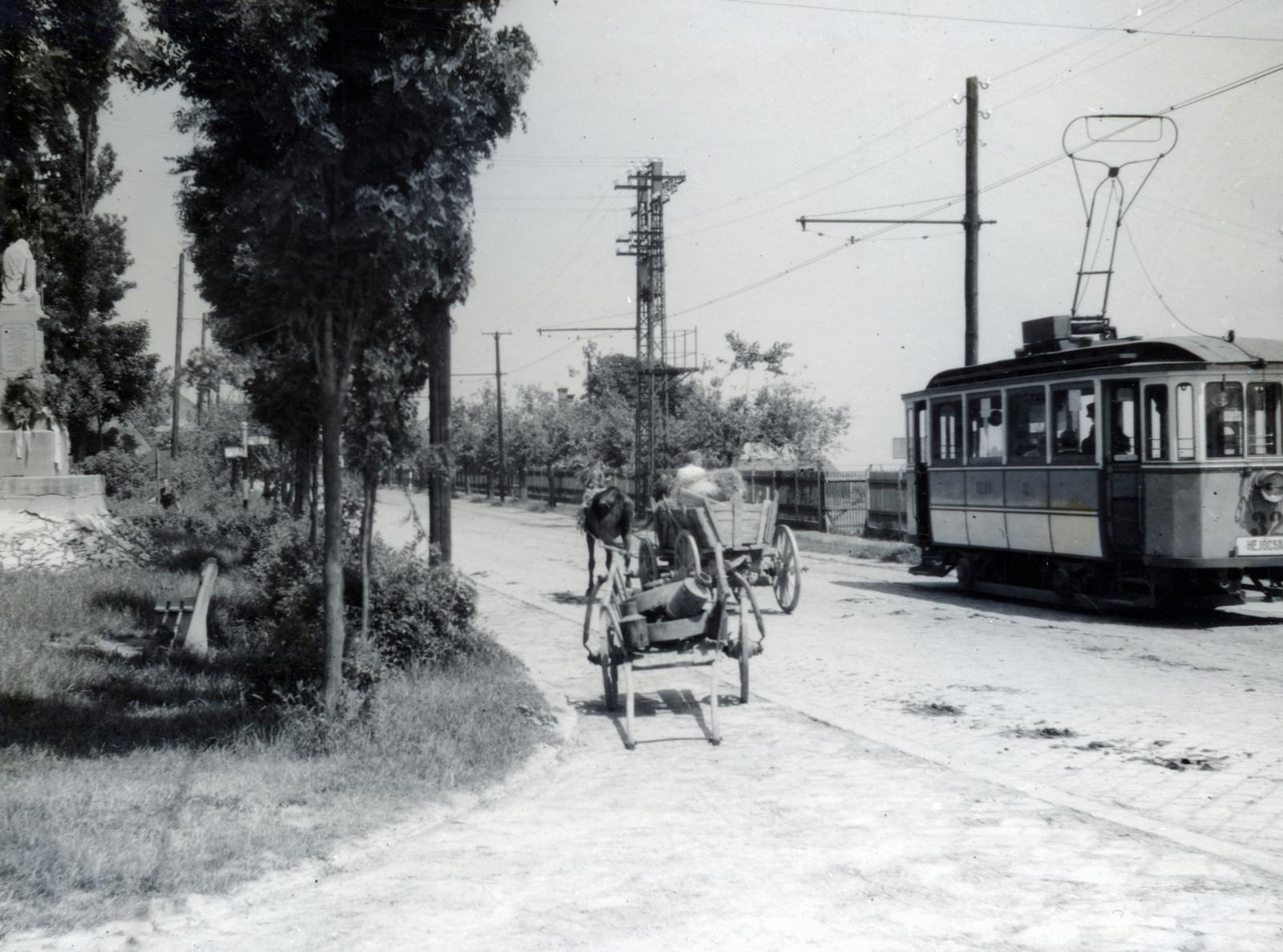 Hungary, Miskolc, Hejőcsaba (ekkor önálló, ma a város része), a Csabavezér út (3-as főút) a Koboz utca (görömbölyitapolcai) elágazásánál. Balra a kis parkban az 1921. augusztus 21-én felavatott I. világháborús emlékmű (Jávorszky Antal kőfaragó) látható, melyen a 32 hazájáért hősi halált halt hejőcsabai katona neve van megörökítve., 1939, Bor Dezső, tram, chariot, Fortepan #231776