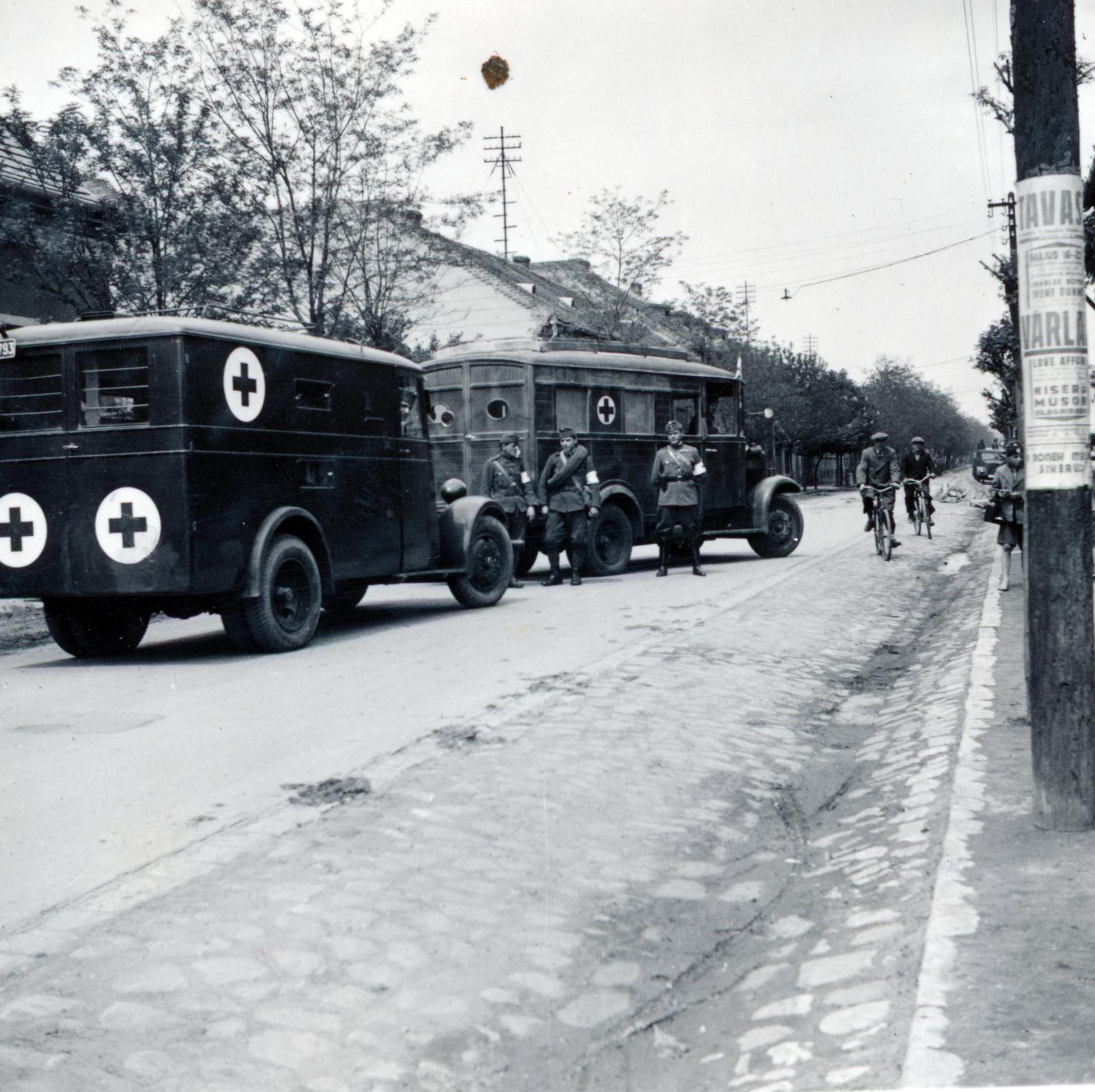 Hungary, Budapest XV., Bocskai utca, mentőautók a 70-72. szám alatti polgári fiúiskola (később Hubay Jenő Zeneiskola és Alapfokú Művészeti Iskola) előtt., 1940, Tordai György, poster, ambulance, bicycle, Budapest, Fortepan #232933